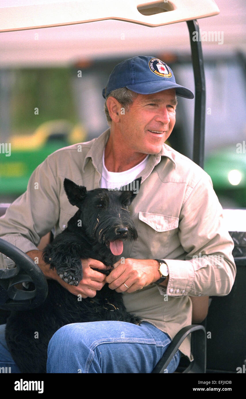 US-Präsident George W. Bush sitzt alleine in einem Golfwagen mit seinem Hund Barney in seinem Schoß auf der Ranch 27. August 2002 in Crawford, Stockfotografie - Alamy