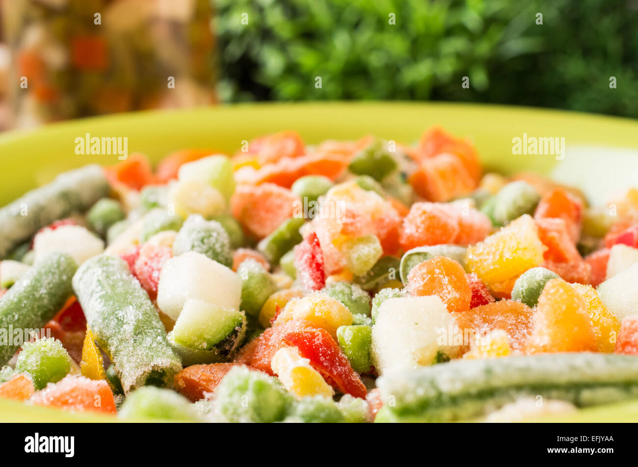 Gefrorenes Gemüse: Erbsen, grüne Bohnen, Mais, Karotten, Paprika in eine Schüssel geben Stockfoto