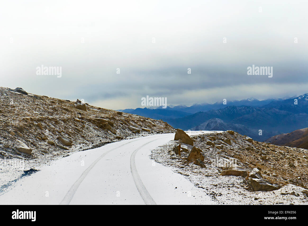 Schneebedeckte Straße auf einem Bergpass im Hintergrund Stockfoto