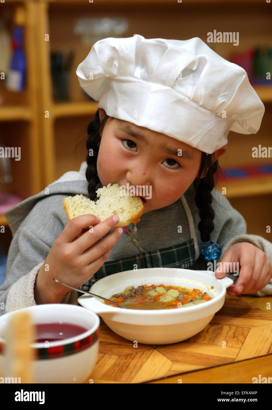 kleines Mädchen mit Mittagessen in einem Kindergarten in Ulanbataar, Mongolei Stockfoto