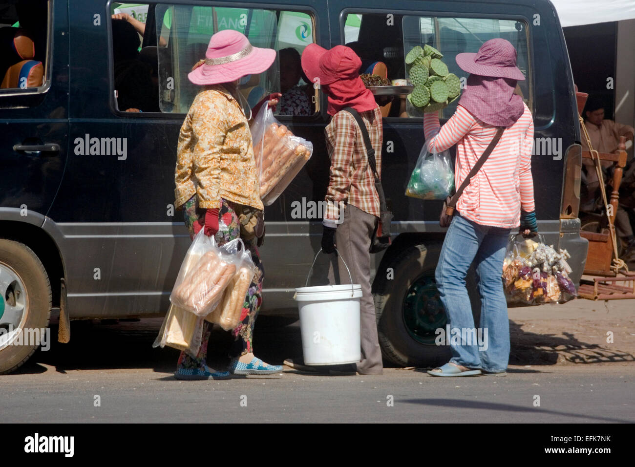 Eine Gruppe von Frauen verkaufen Suppen für Passagiere in einem Mini-van auf eine Stadt Straße in Kampong Cham, Kambodscha. Stockfoto