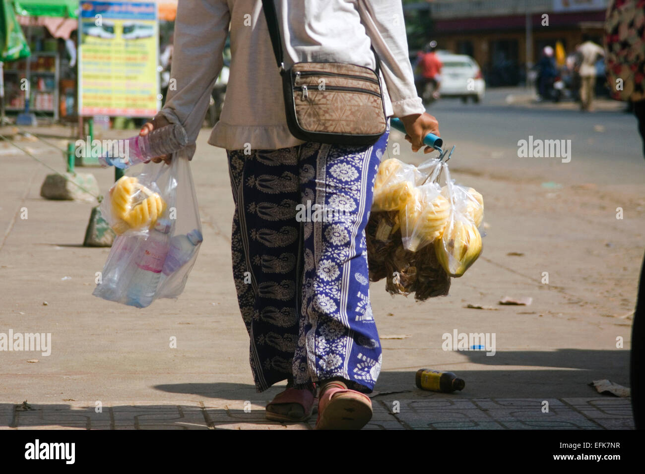 Eine Frau trägt in Scheiben geschnittene Ananas, die sie als Straße Nahrung auf eine Stadt in Kampong Cham, Kambodscha Straße verkauft. Stockfoto