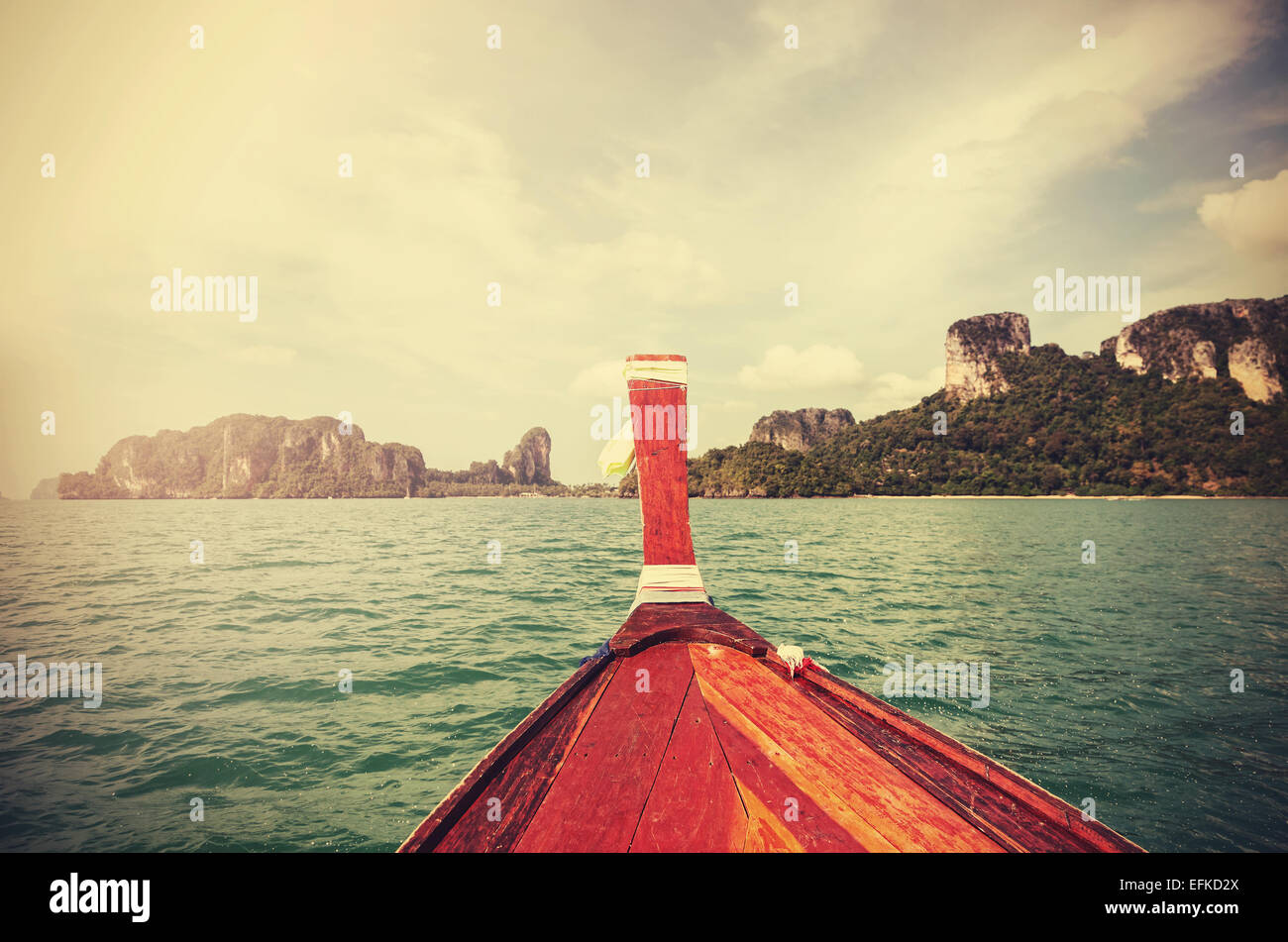 Retro getönten Holzboot und eine tropische Insel im Abstand. Stockfoto