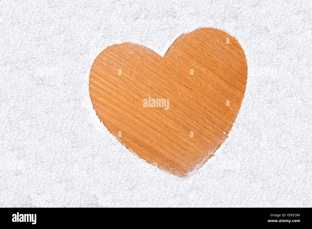 Herzen im Schnee auf einem hölzernen Hintergrund. Stockfoto