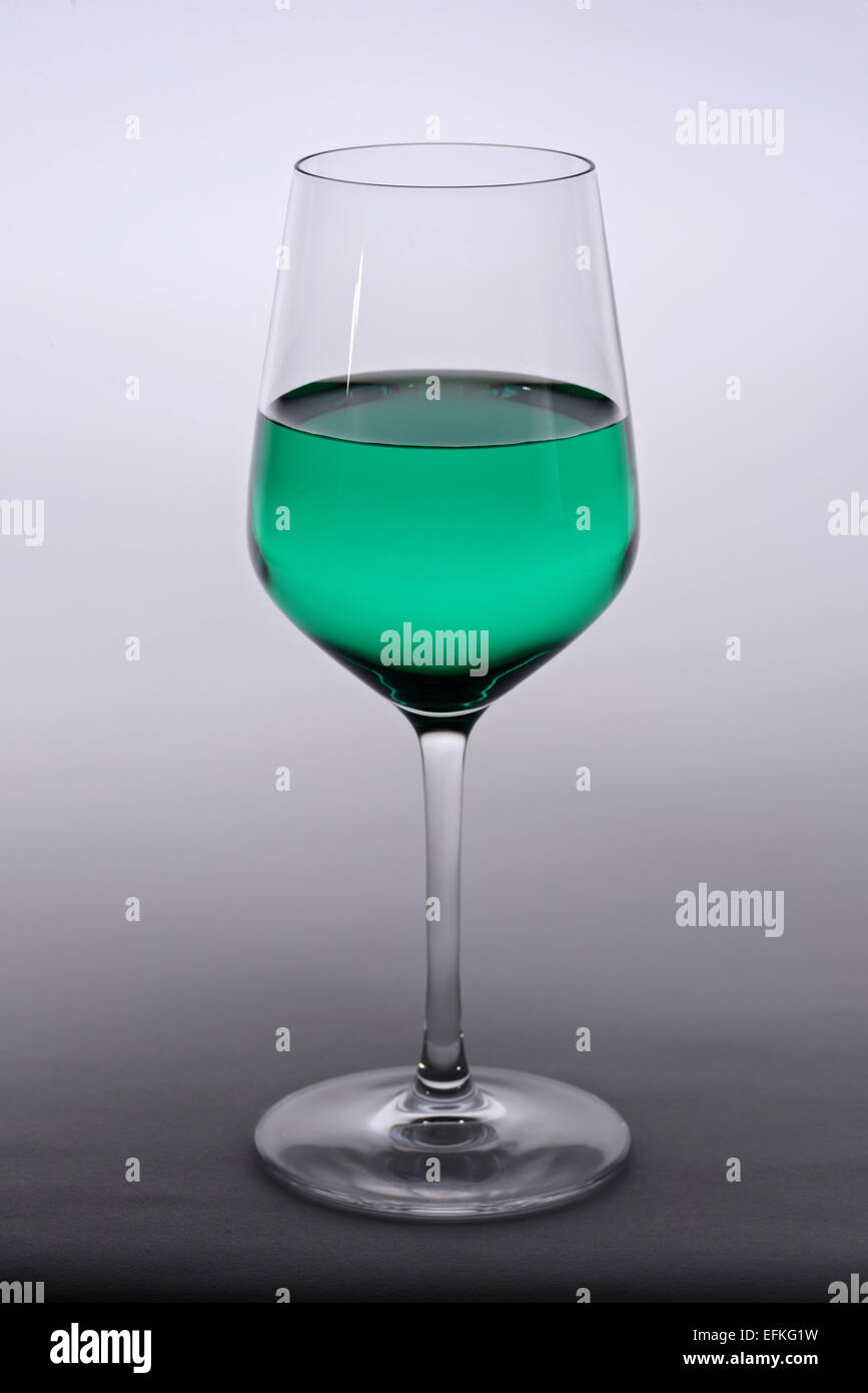 Weinglas mit grün gefärbte Flüssigkeit Stockfoto