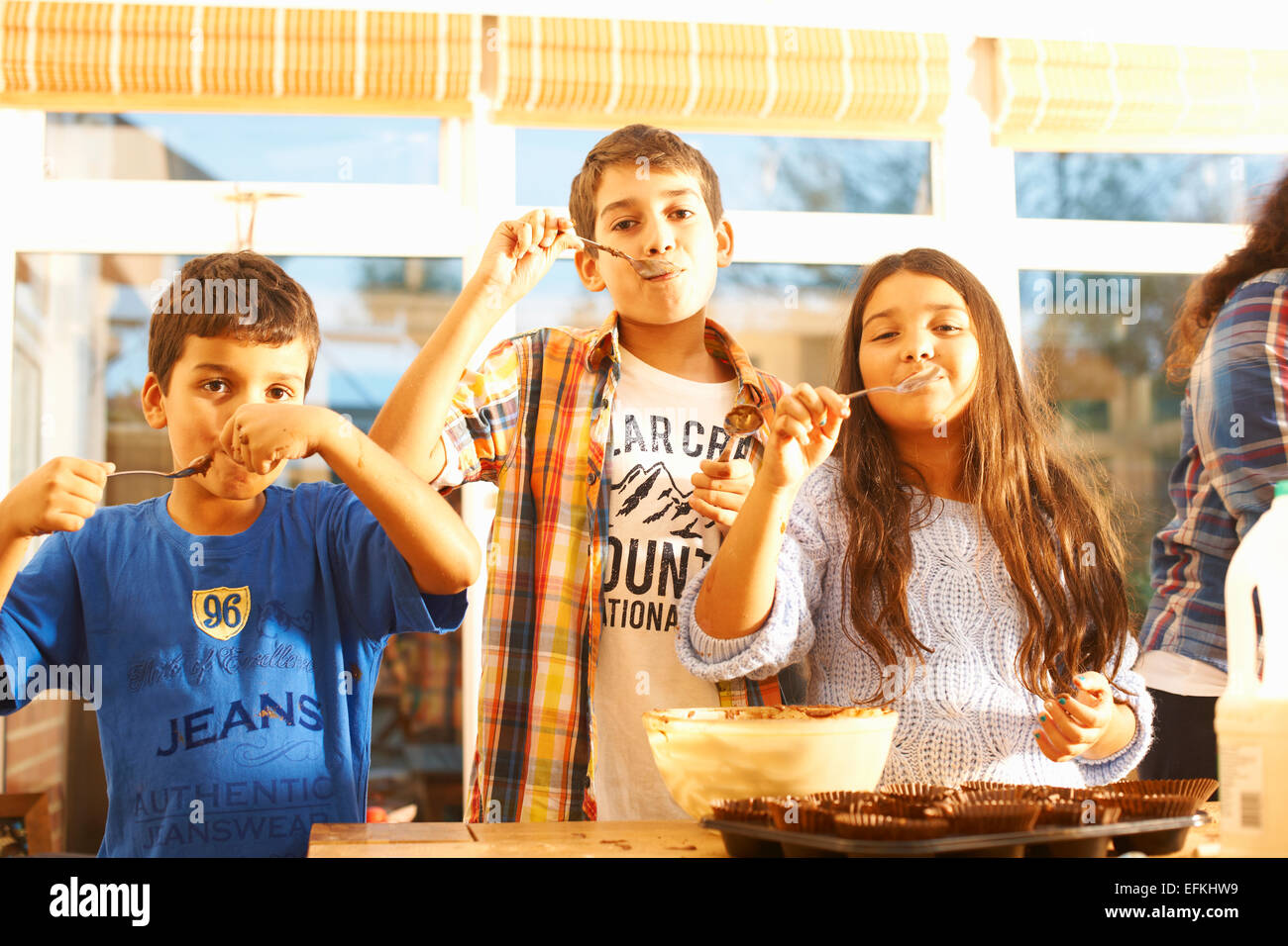 Kinder, die Verkostung Kuchenteig in Küche Stockfoto