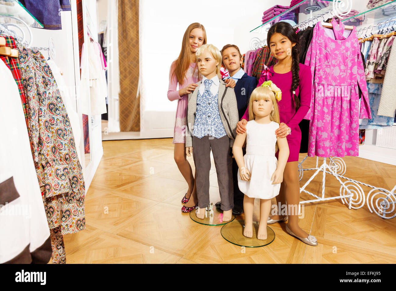 Kinder stehen mit zwei Figuren im shop Stockfoto