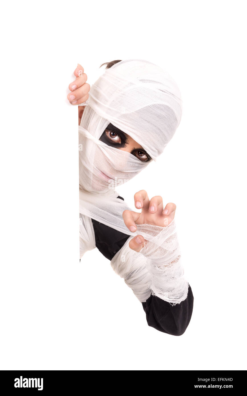 Junge mit Mumienkostüm in Halloween isoliert in weiß über ein leeres Brett Stockfoto