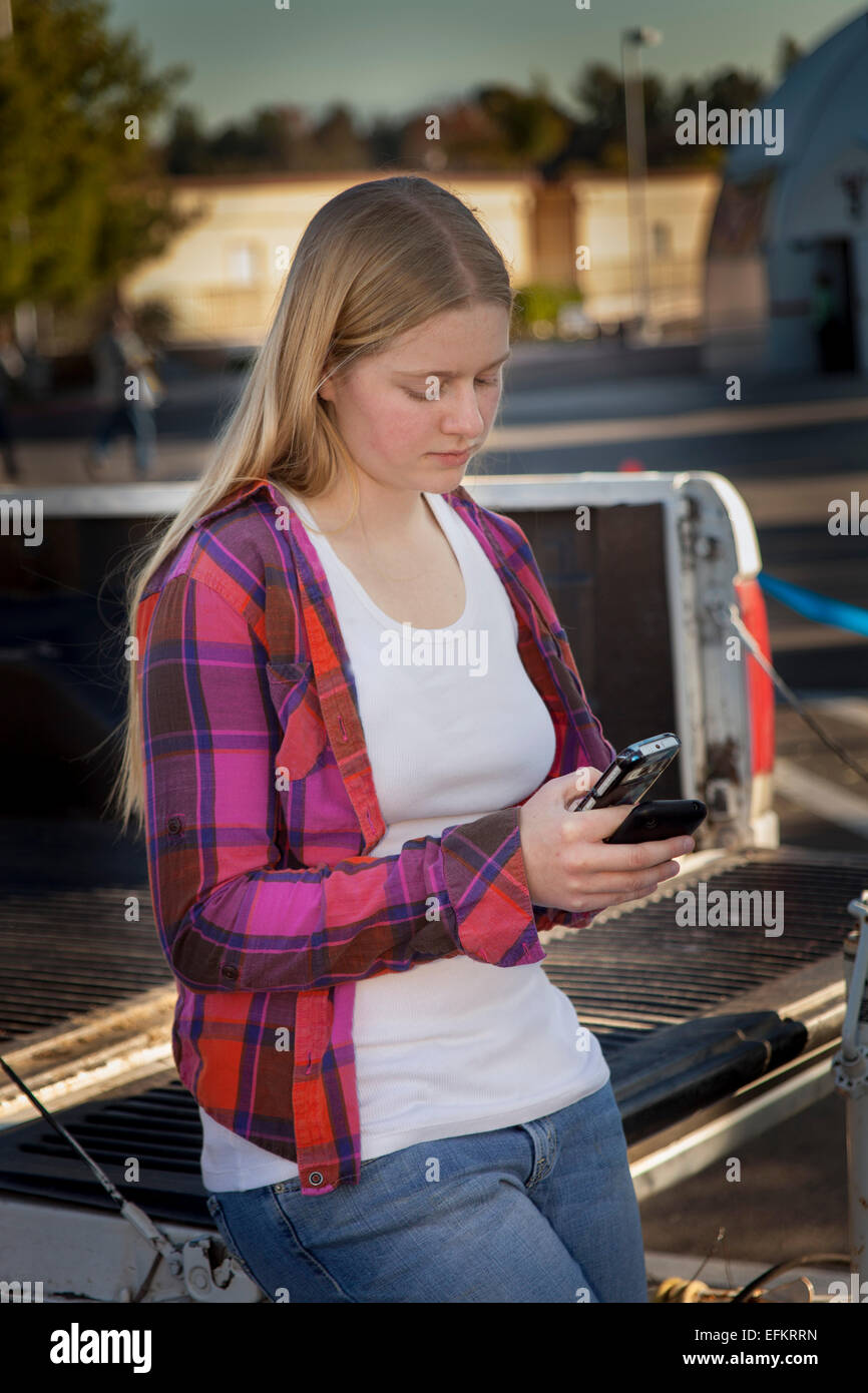 Junge mensch leute jugendlich Mädchen mit iPhone mobile Gerät im Freien hängen, während sie darauf warten. Herr © Myrleen Pearson Stockfoto