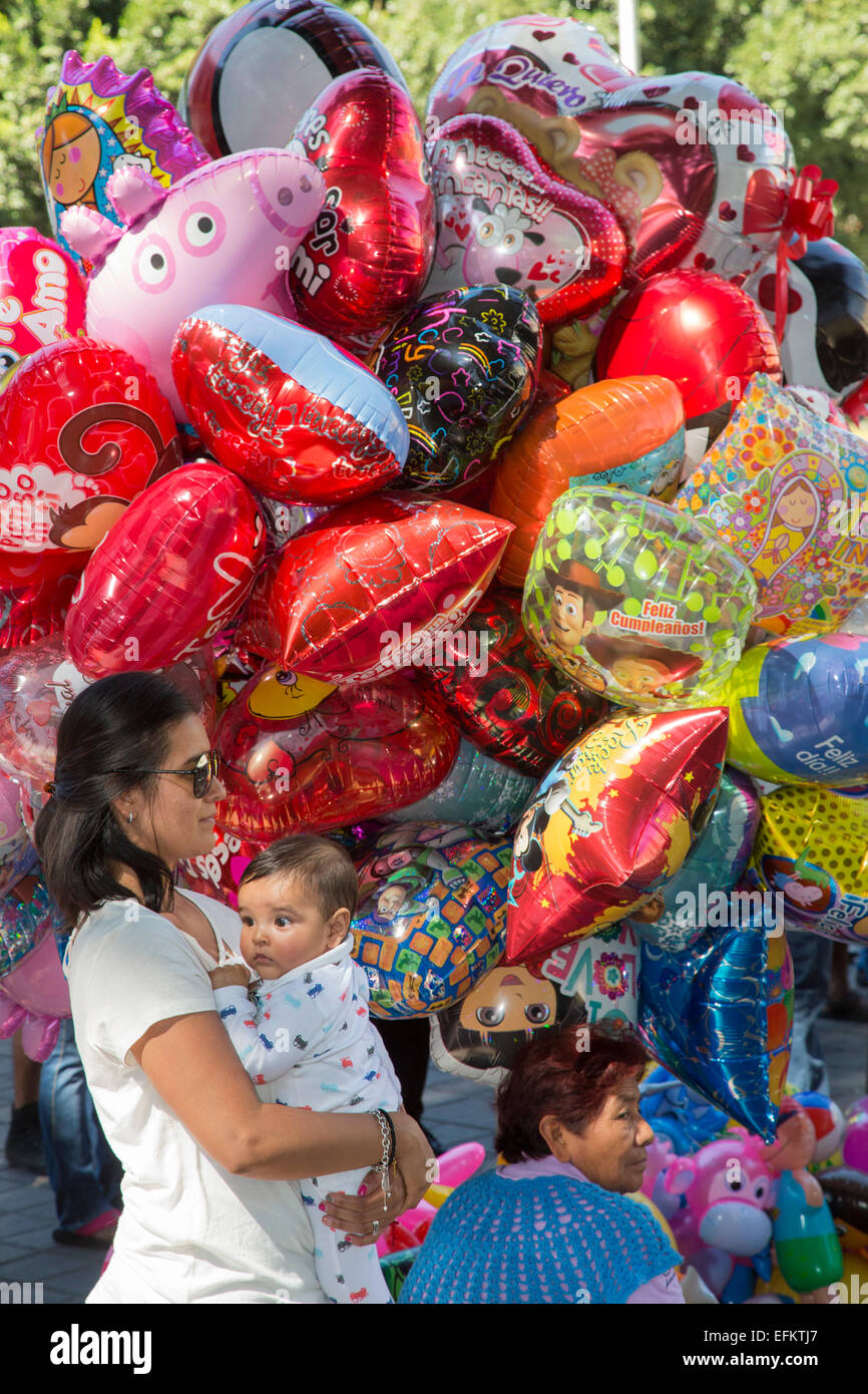 Oaxaca, Mexiko - eine Frau und ihr Baby neben einem Ballon-Verkäufer in den Zócalo (Hauptplatz). Stockfoto