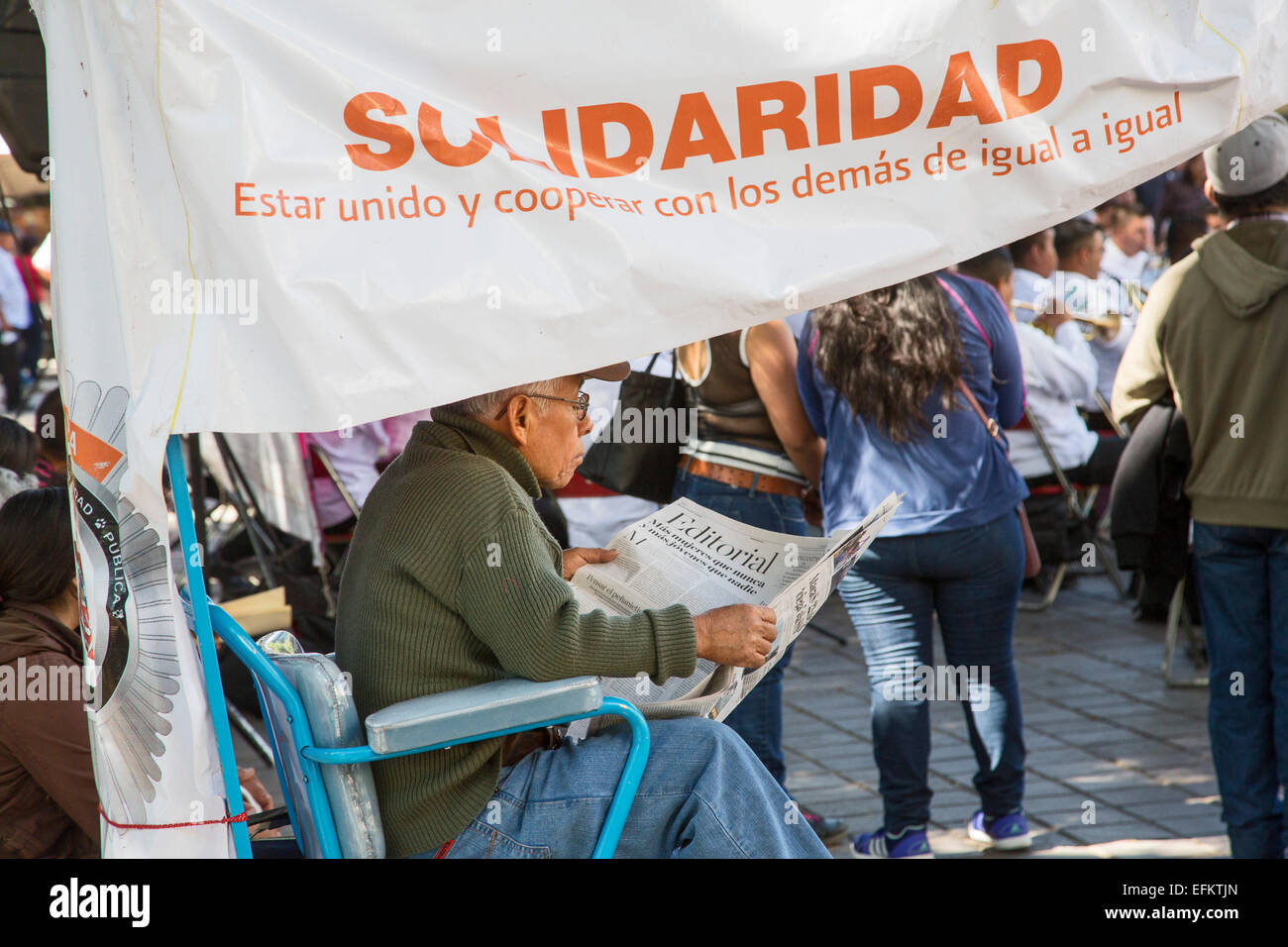 Oaxaca, Mexiko - ein Schuh-Glanz-Mann liest Zeitung während des Wartens auf den Kunden an seinem Stand in der Zócalo (Hauptplatz). Stockfoto