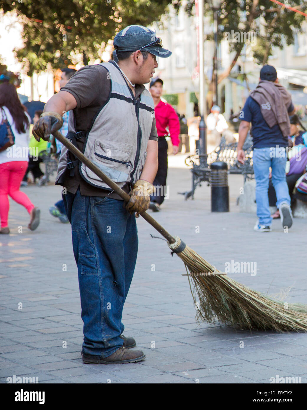 Oaxaca, Mexiko - ein Arbeiter fegt eine Fußgängerzone in der Zócalo mit einem handgemachten Besen. Stockfoto