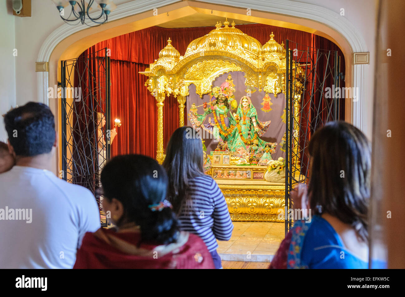 Anzahl von Menschen singen, tanzen und beten an einem Hare-Krishna-altar Stockfoto