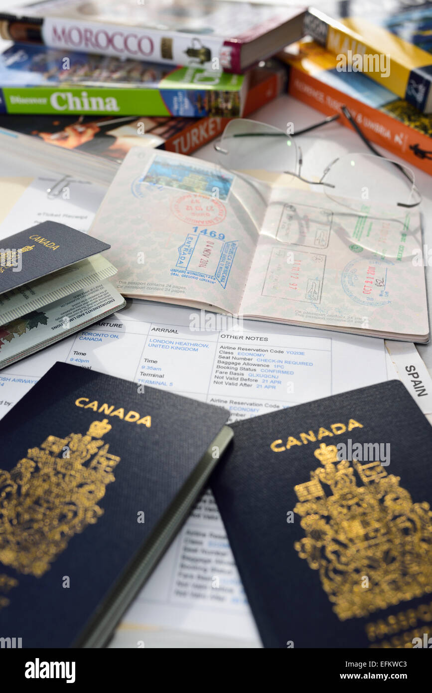 Vorbereitung für internationale Urlaubsreisen mit Reiseführer, Flug-Route und kanadischen Pässen Stockfoto