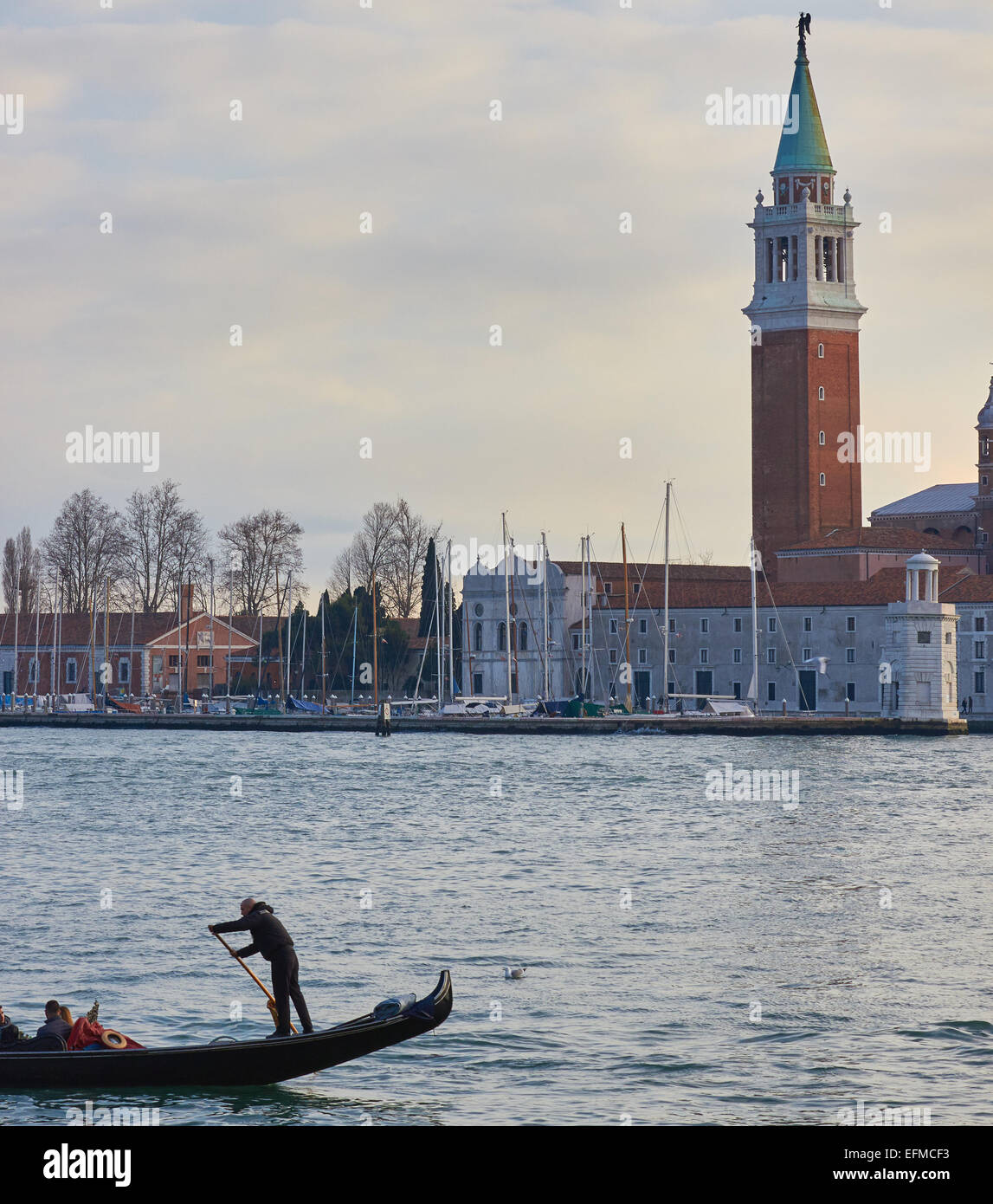 Gondoliere Rudern auf die Lagune von Venedig mit Insel San Giorgio Maggiore im Hintergrund Veneto Italien Europa Stockfoto