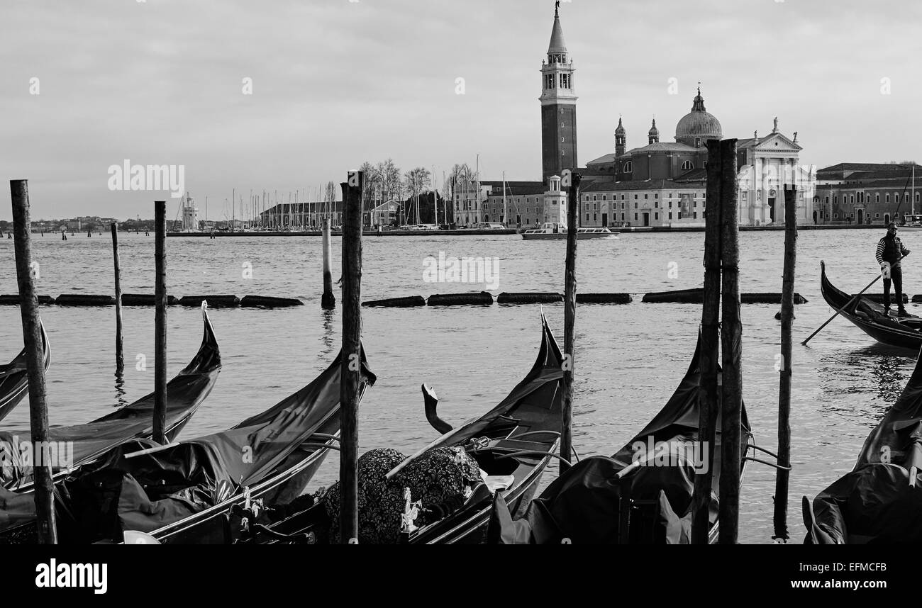 Gondeln und Gondoliere Rudern auf die Lagune von Venedig mit Insel und Kirche von San Giorgio Maggiore im Hintergrund Veneto Italien Europa Stockfoto