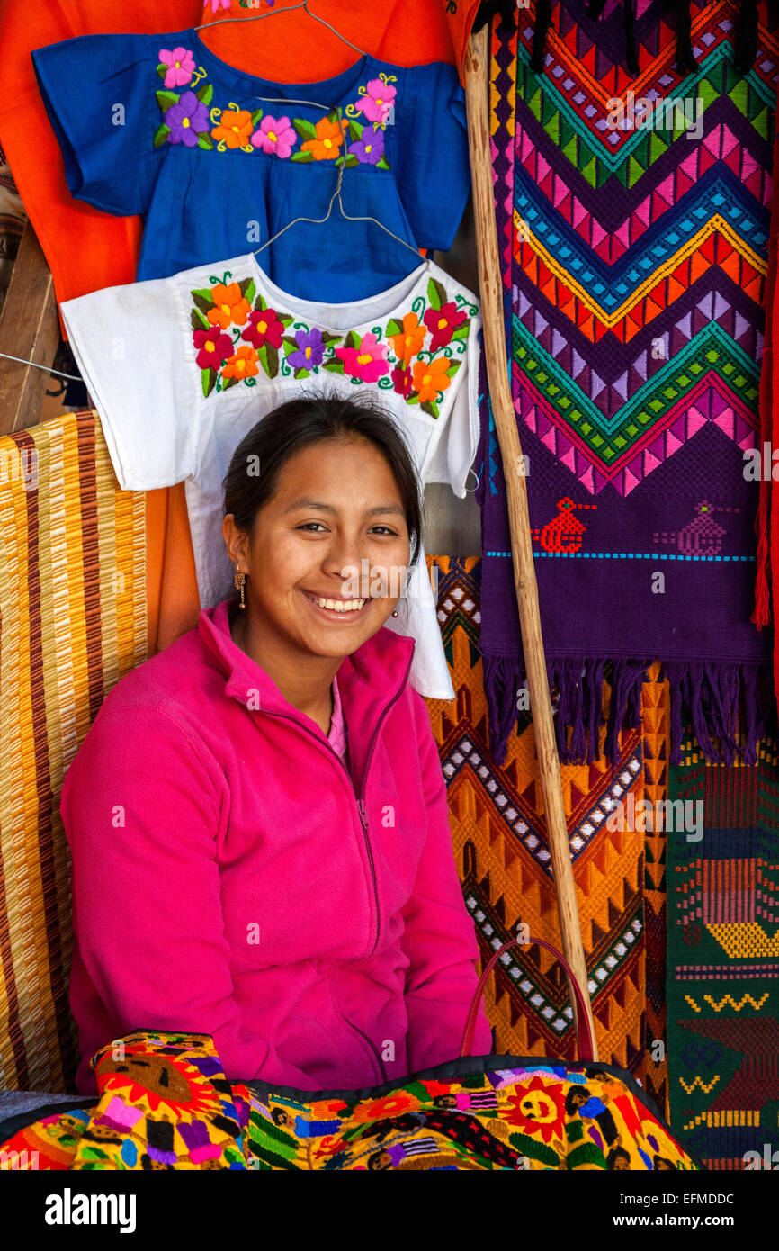 Chichicastenango, Guatemala.  Quiche Frau verkaufen bunte Kleidung und Wandbehänge. Stockfoto