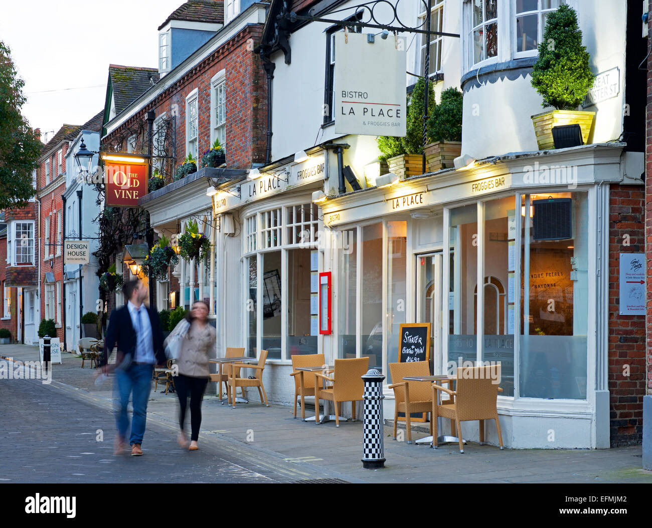 Paar zu Fuß vorbei an La Place Bistro und der alten Rebe Pub in Winchester, Hampshire, England UK Stockfoto