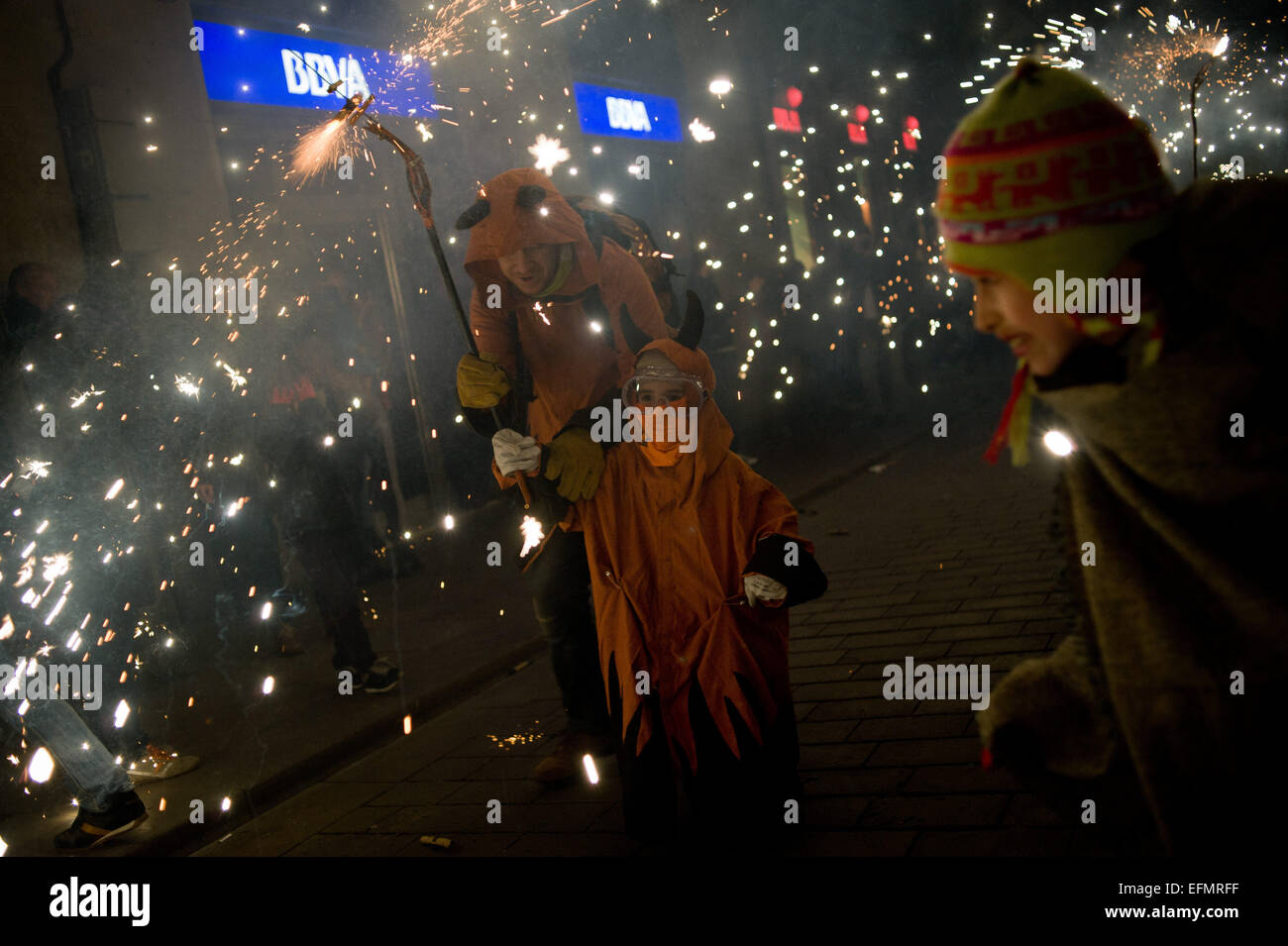 Barcelona, Katalonien, Spanien. 7. Februar 2015. Ein Junge Teufel wird geholfen, Feuerwerk in den Straßen des gotischen Viertels von Barcelona für Santa Eulalia Festival zu tragen. Im Rahmen der Feierlichkeiten von Santa Eulalia fand eine Kinder-"Correfoc" in den Gassen des gotischen Viertels von Barcelona statt. Correfocs sind eine alte katalanische Tradition, wo Menschen als Teufel und leichte Feuerwerkskörper und Fackeln zu kleiden. Bildnachweis: Jordi Boixareu/ZUMA Draht/Alamy Live-Nachrichten Stockfoto