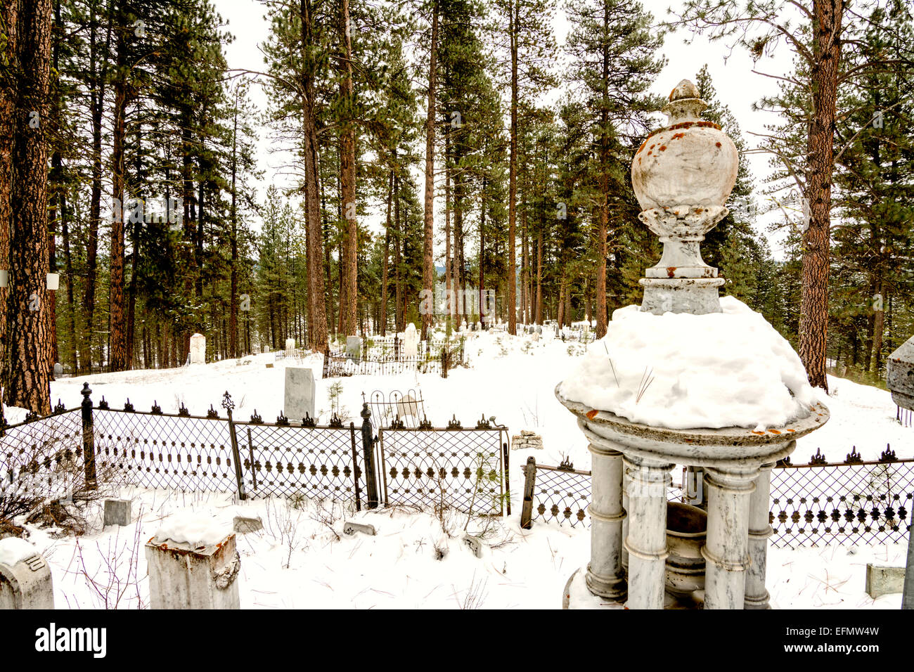 Schneebedeckte Grabstein auf einem Bergfriedhof Stockfoto