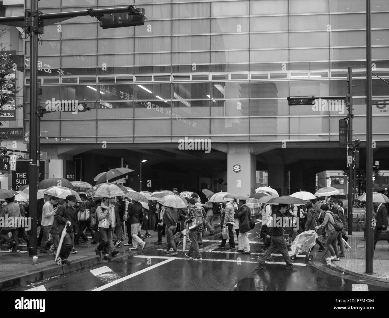 Schwarz / weiß Bild von Passanten auf der Straße mit öffnen Sonnenschirme im Regen Stockfoto
