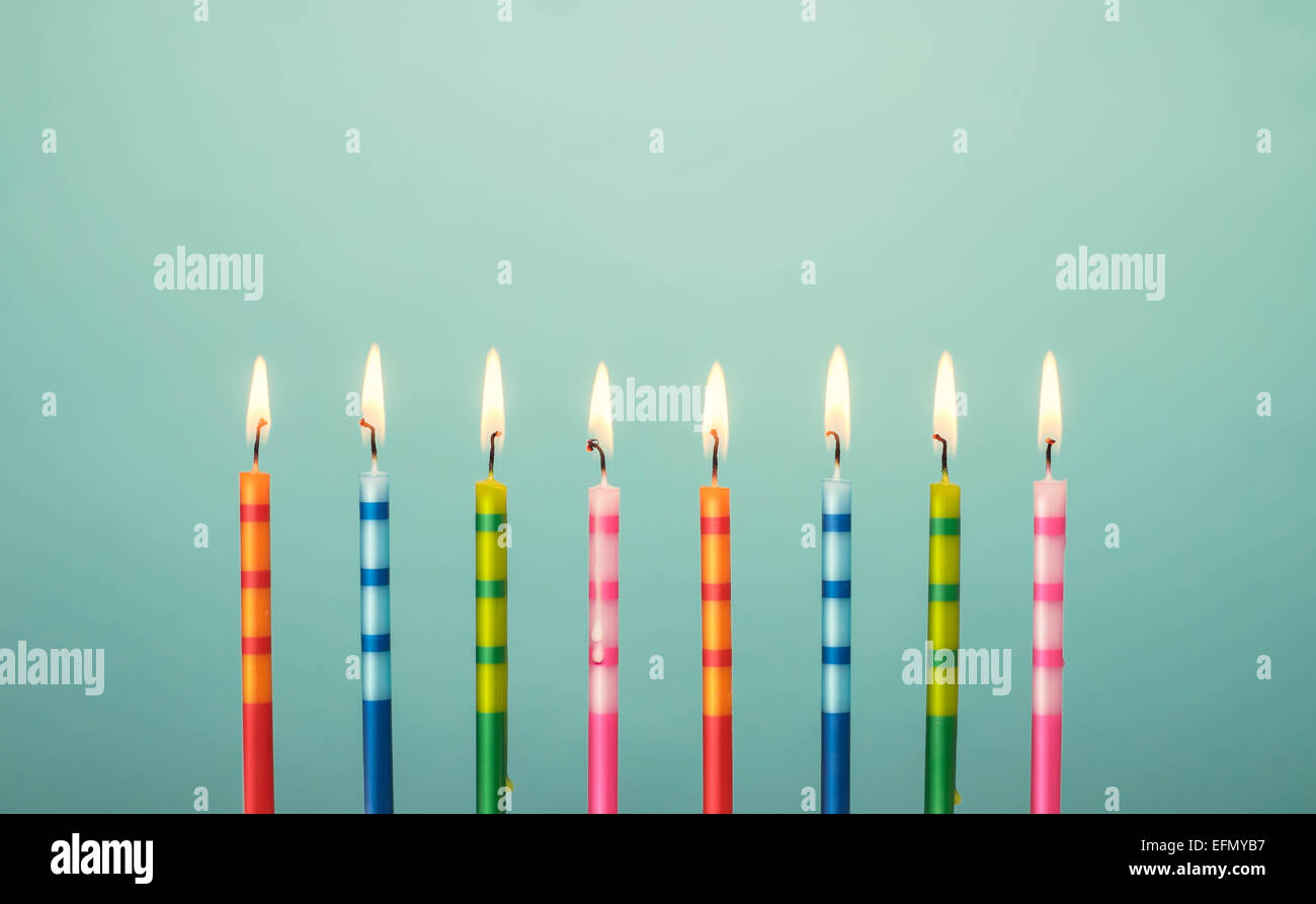 Feier-Kerzen in verschiedenen Farben und Streifen beleuchtet Stockfoto