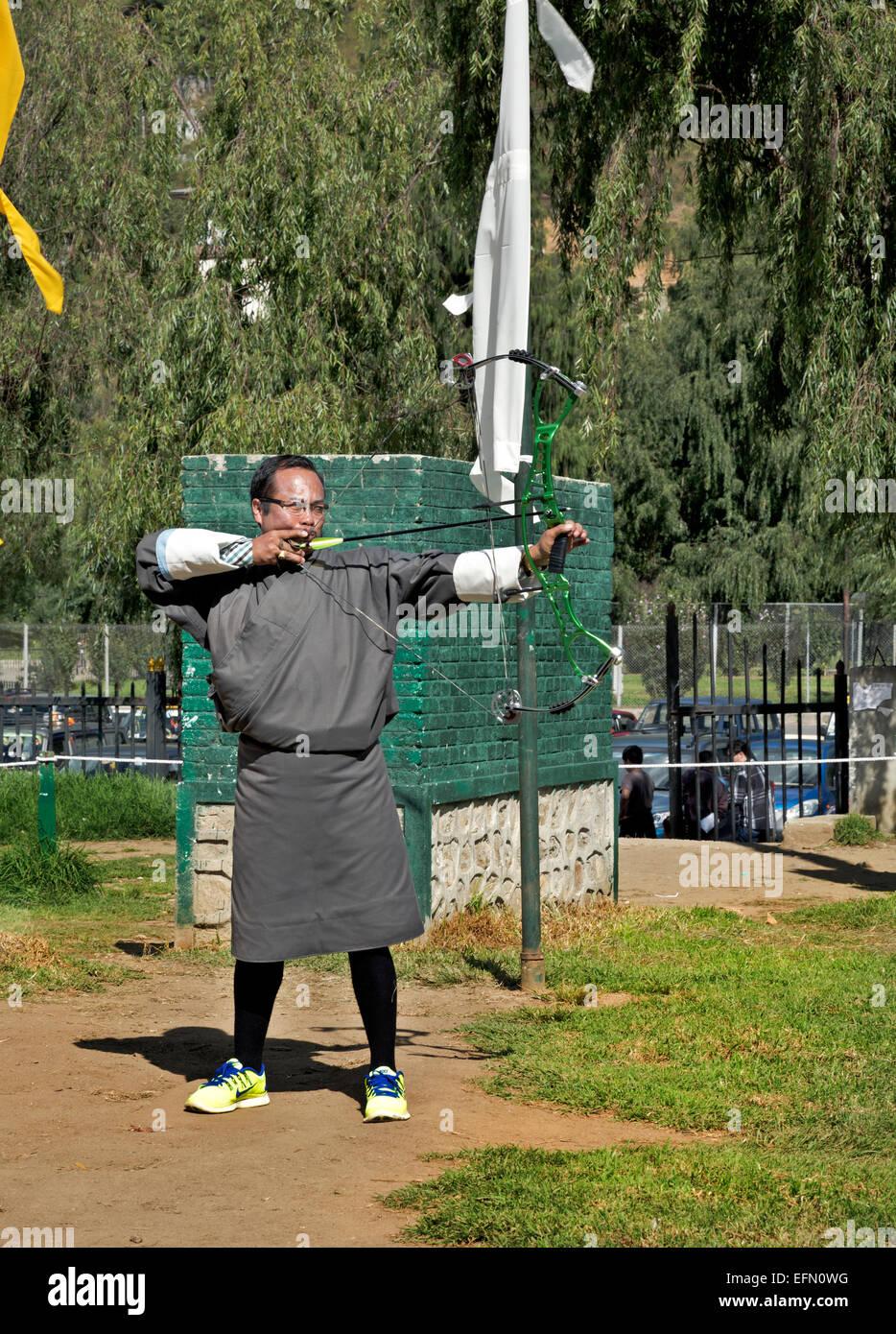 BU00056-00... BHUTAN - Archer in traditioneller Tracht (ein Gho) Teilnahme an einem Turnier 145 Meter auf ein Ziel schießen. Stockfoto