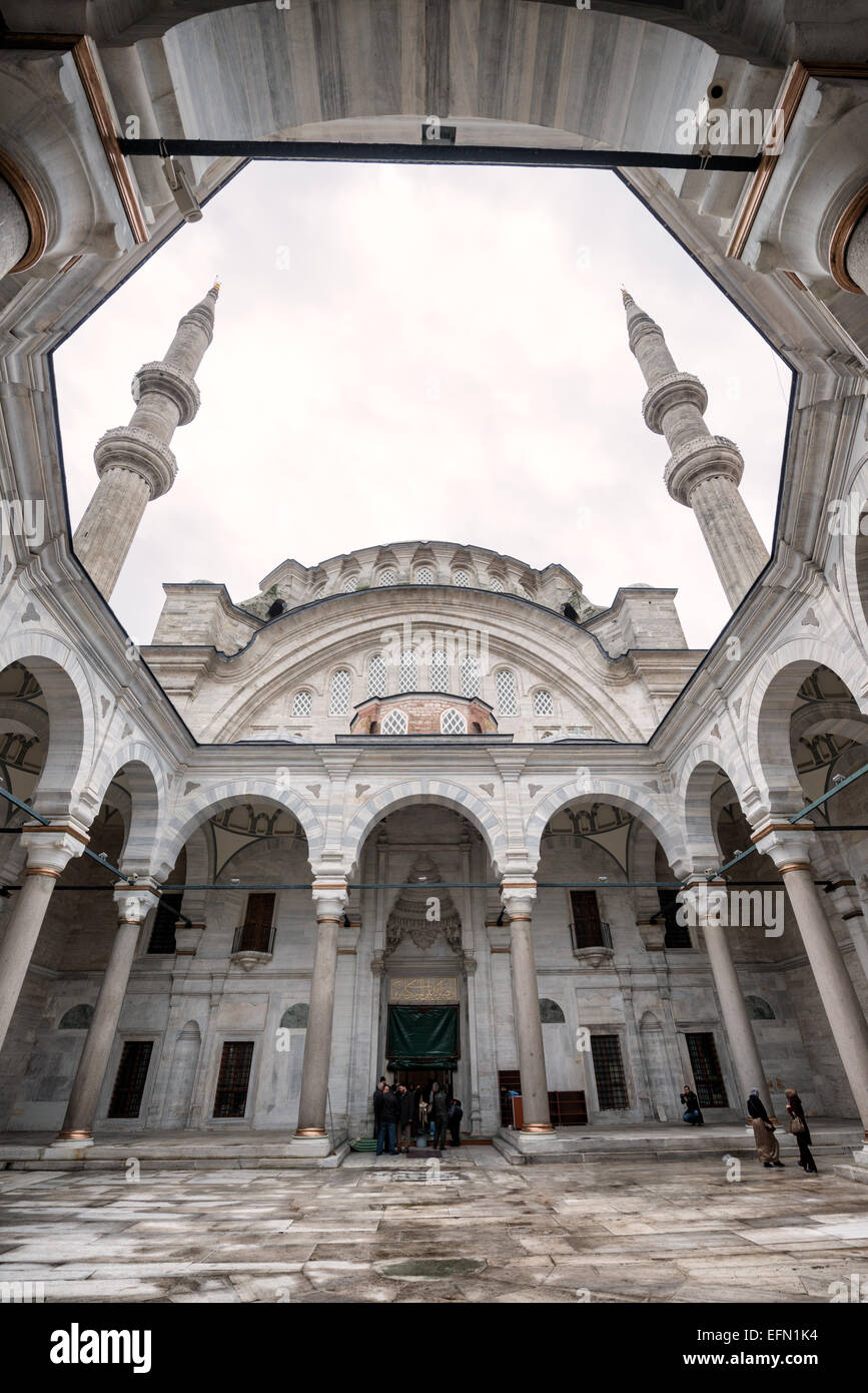 ISTANBUL, Türkei – der unverwechselbare hufeisenförmige Innenhof der Nuruosmaniye-Moschee verfügt über ein innovatives polyeckiges Klosterdesign, das in der osmanischen Architektur einzigartig ist. Diese 1755 fertiggestellte halbkreisförmige Kolonnade stellt eine dramatische Abkehr von den traditionellen rechteckigen Höfen der Moschee dar und veranschaulicht den osmanischen Barock. Die ungewöhnlich geschwungene Form des Hofes zeigt die architektonischen Experimente dieser Zeit. Stockfoto