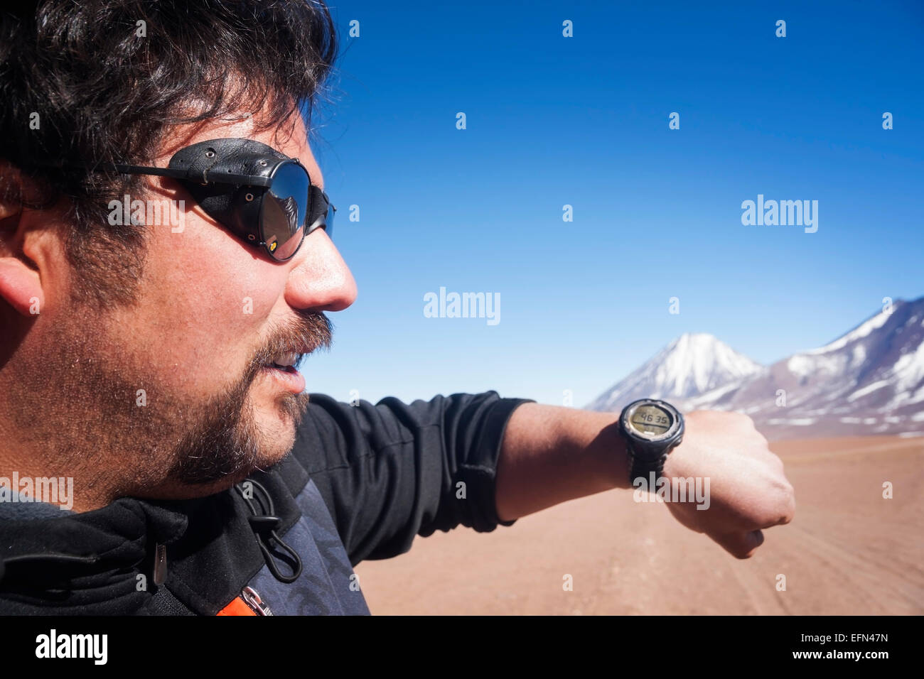 Chilenische Mann Brille Gletscher hält Arm GPS Höhe 4635 Metern Höhe in der Nähe von Licancabur Vulkan anzeigen Stockfoto