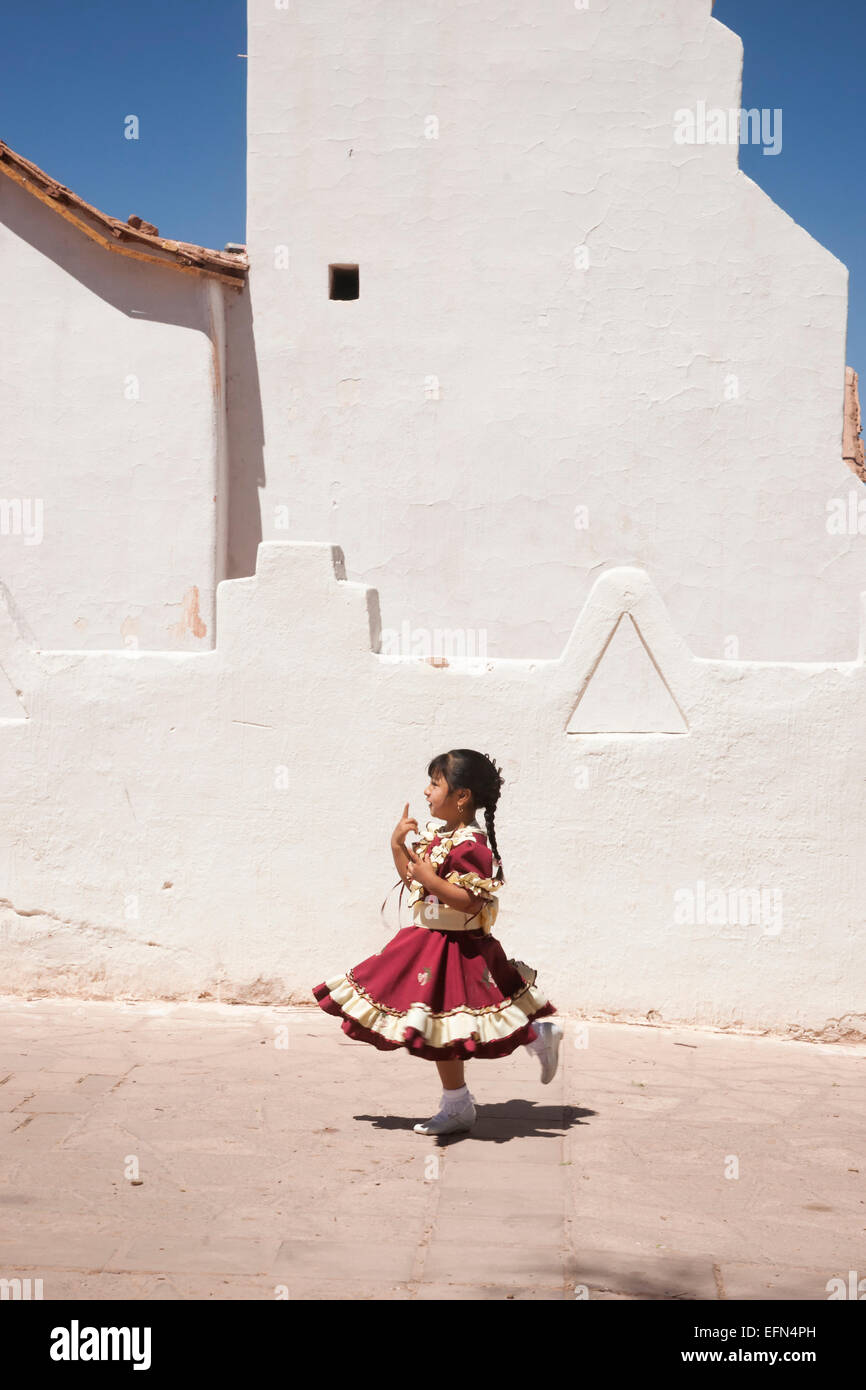 Kleines Mädchen verkleidet für Sept 18 Unabhängigkeitstag Urlaub tanzt vor Adobe Kirche San Pedro, San Pedro, Chile, Süd A Stockfoto