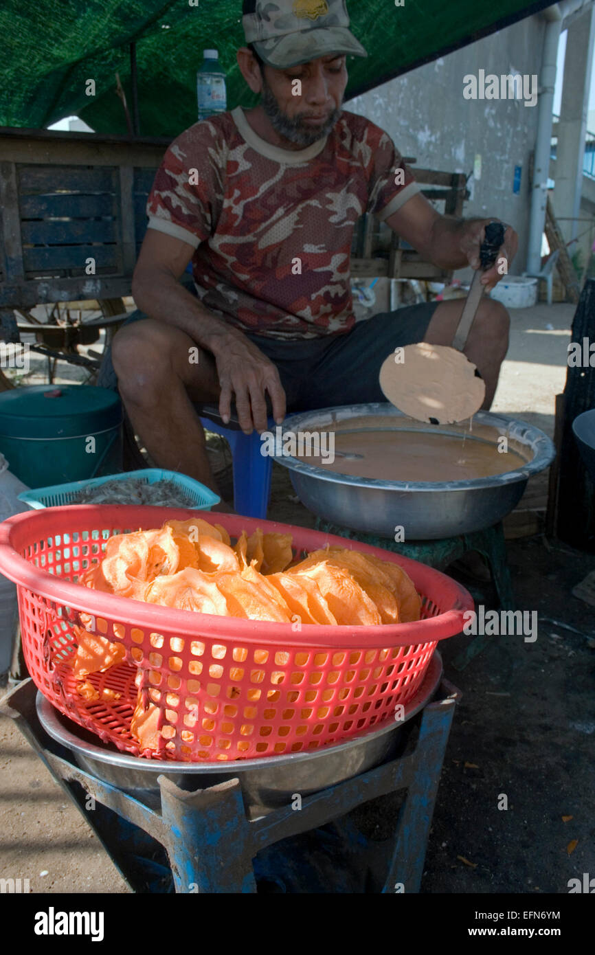 Ein Mann ist knackig Streetfood auf einer Stadtstraße unter einer Brücke in Kampong Cham, Kambodscha kochen. Stockfoto