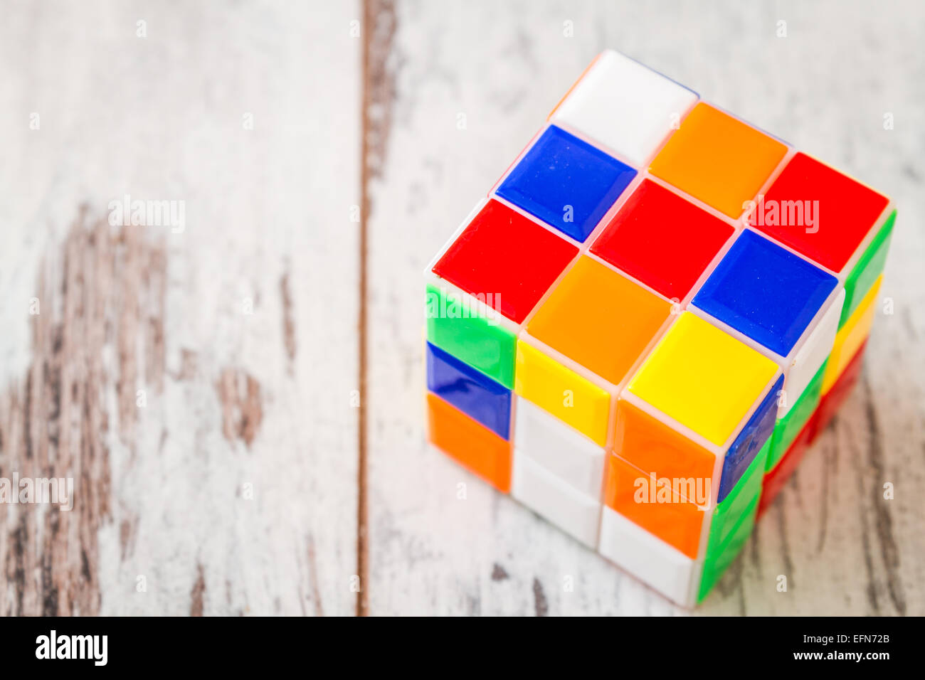 Jigsaw Puzzle Rubik Cube Spielzeug, multicolor Kunststoffblöcke auf weißem Holz Hintergrund Stockfoto