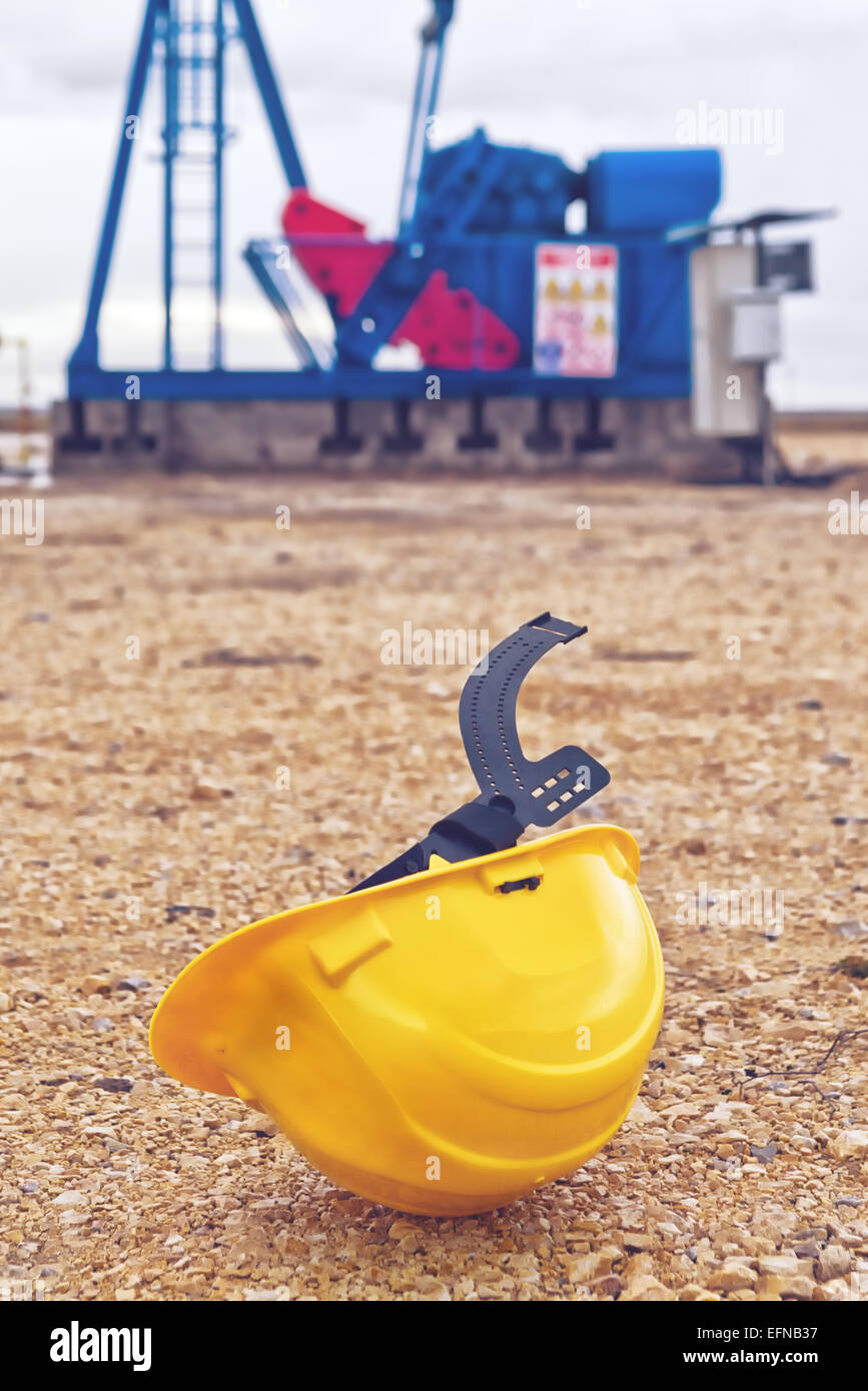 Schützende Helm und Bohrschwengels Ölpumpe auf Erdgas in das Feld Pumpen aus der Ölquelle. Stockfoto