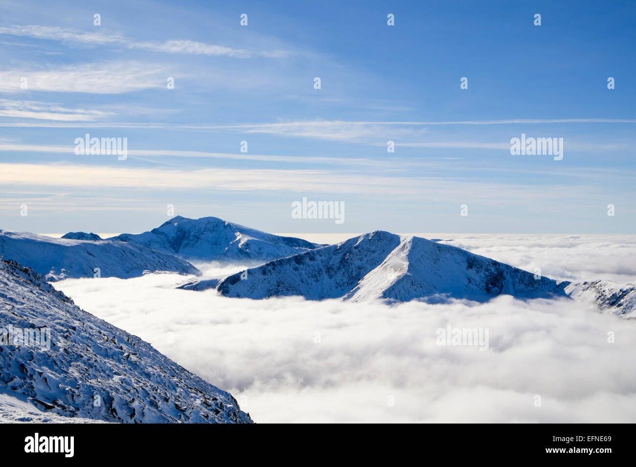 Mount Snowdon und Y Garn Gipfeln oberhalb der niedrigen Cloud von Temperaturinversion in Tal im Winter in den Bergen von Snowdonia Wales UK Großbritannien verursacht Stockfoto