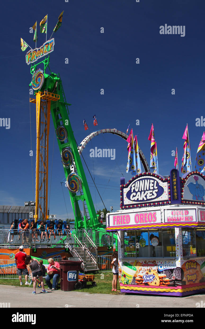 Trichter Kuchen. Fried Oreo Kekse. Kalte Getränke. Melden Sie sich am Getränkestand. Eine Fahrt mit Karneval namens Raserei im Hintergrund. Canfield Fair. Stockfoto