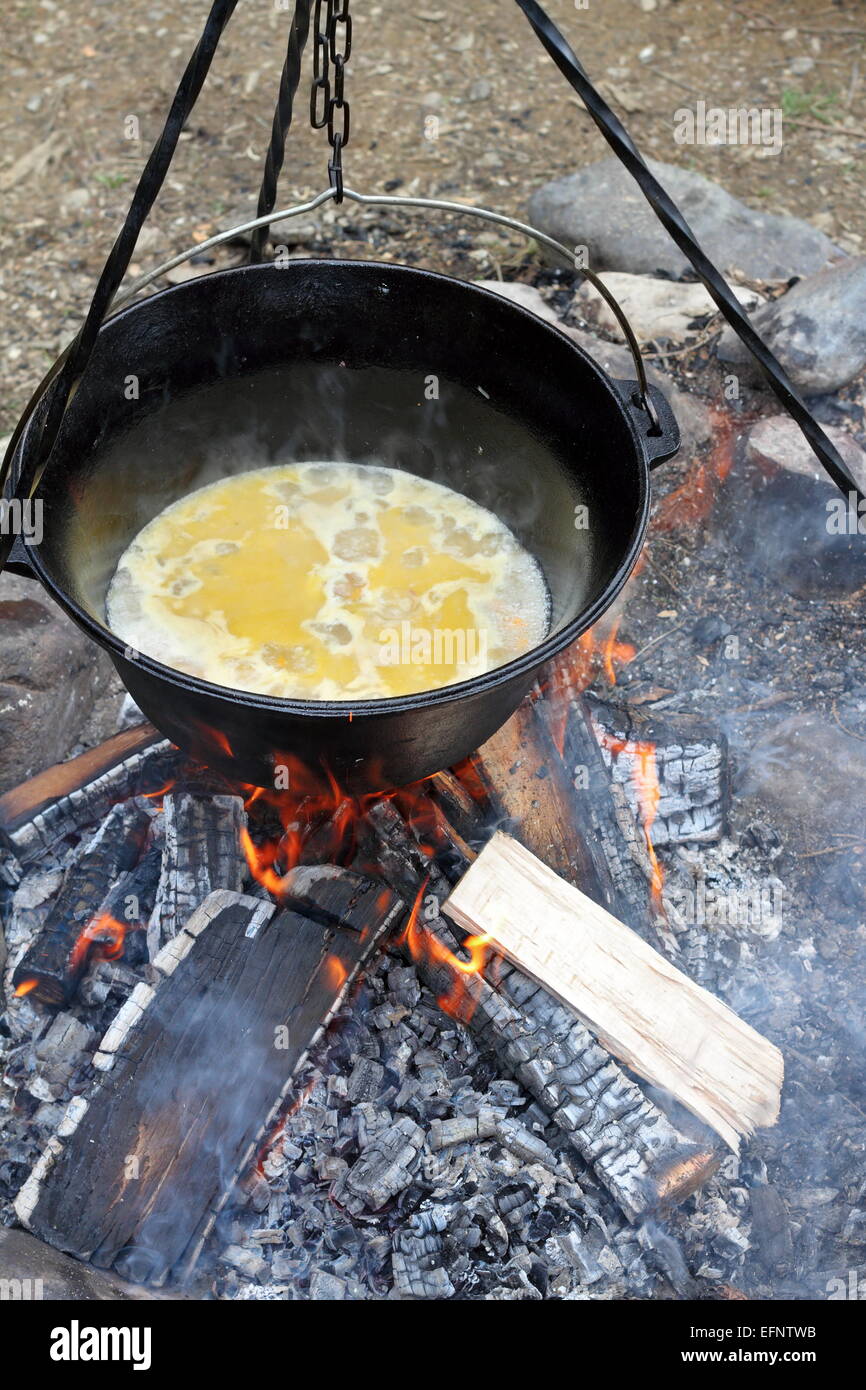 Zubereitung von Essen am Lagerfeuer, Kochen in großen Metall-Kessel Stockfoto