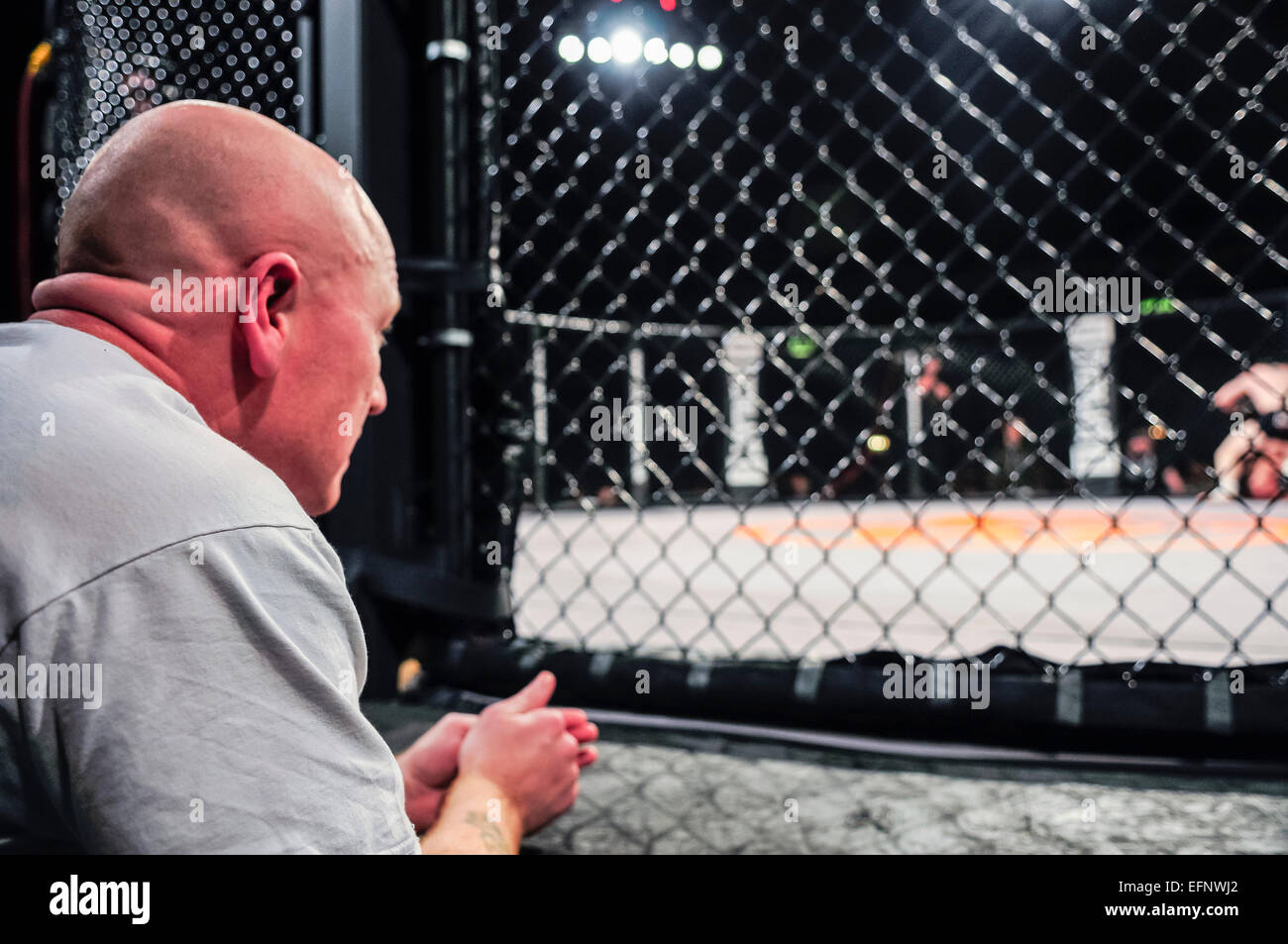 MMA Trainer beobachtet von der Seite, wie einer seiner Kämpfer im Ring ist. Stockfoto