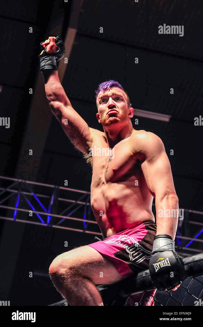 MMA-Kämpfer Peter Duncan klettert nach dem Sieg auf den Käfig. Stockfoto