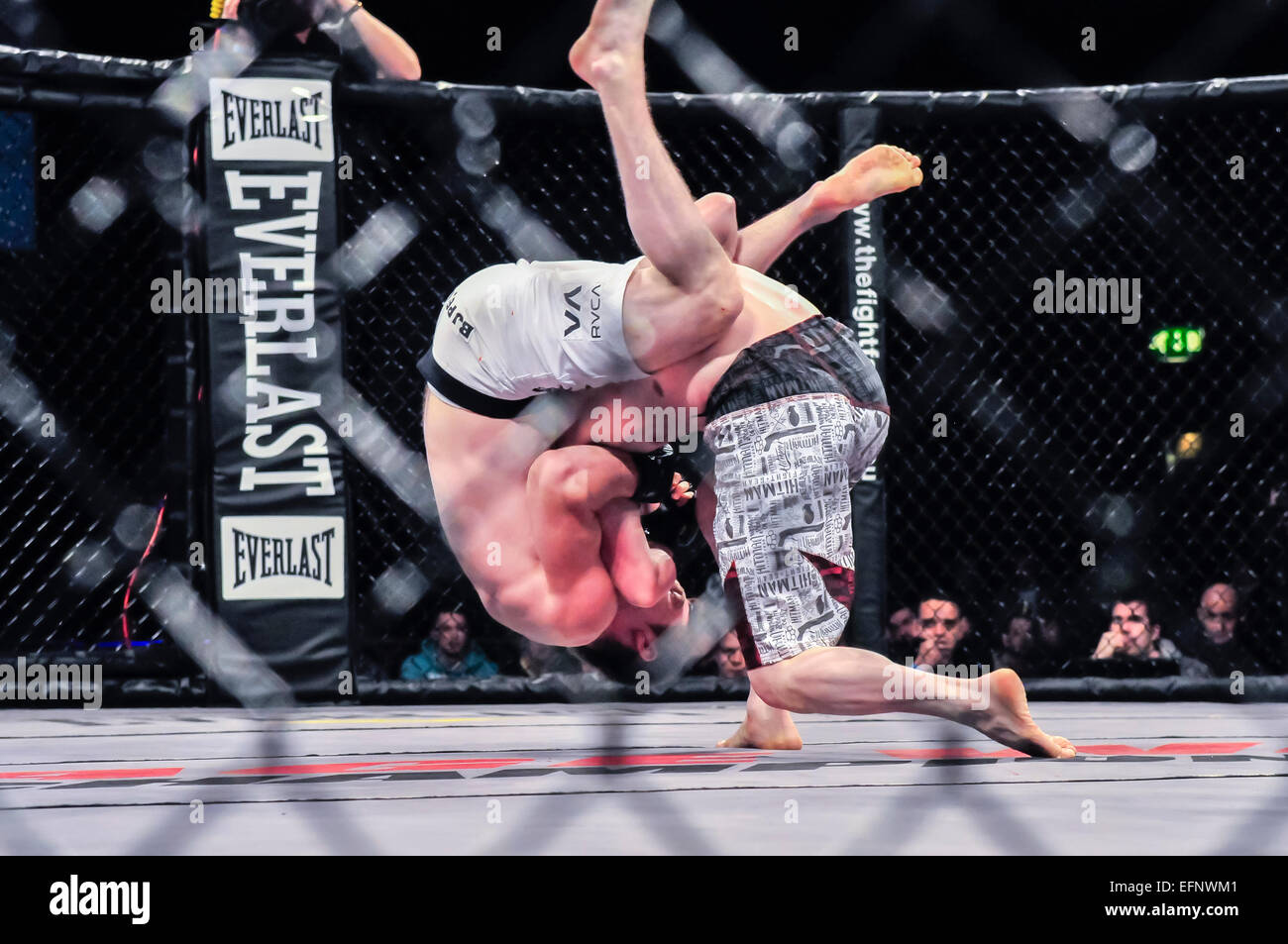 MMA-Kämpfer hebt seinen Gegner und wirft ihn auf die Leinwand Stockfoto