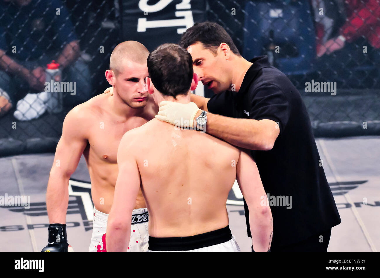 Schiedsrichter in einem MMA Käfig kämpfen spricht mit Kämpfer, bevor das Spiel beginnt Stockfoto