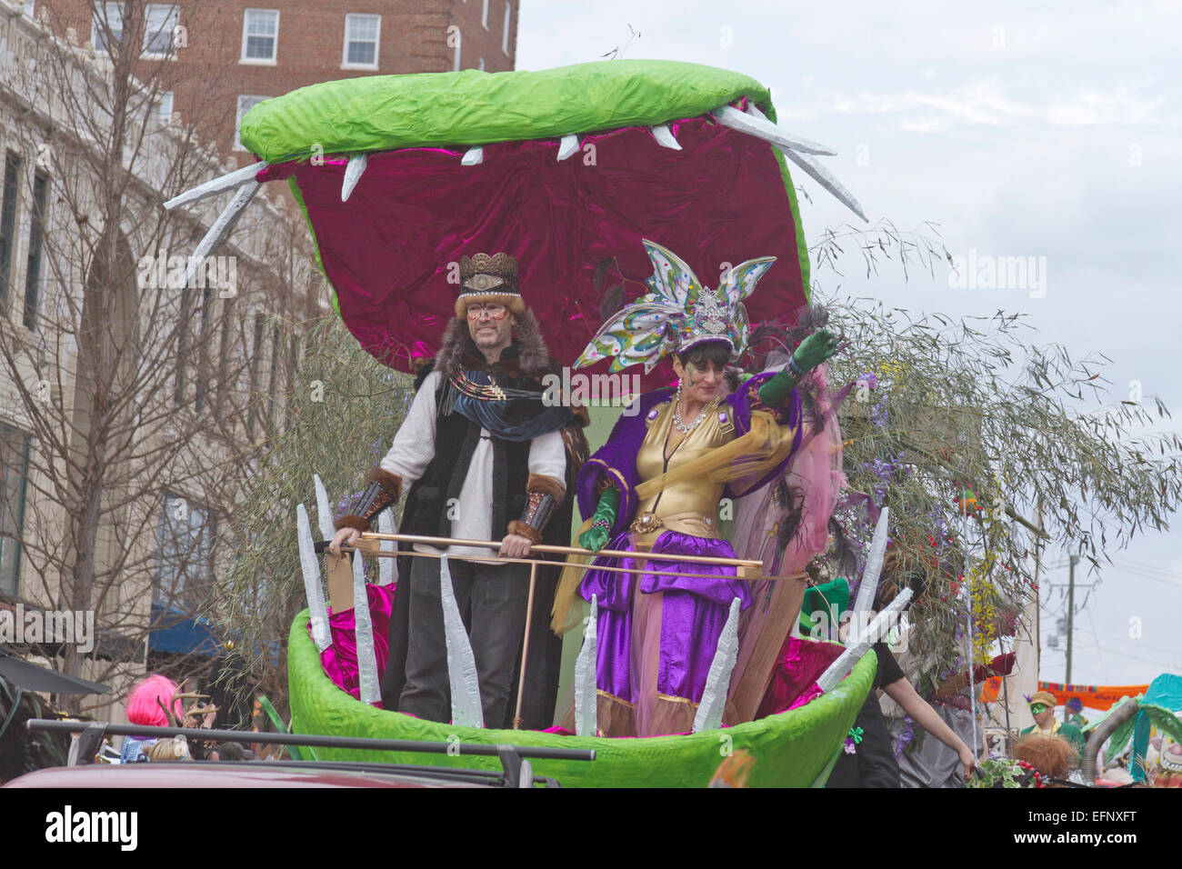 Der König und die Königin von Misrule Welle zu ihren Untertanen aus einem Schwimmer in der Feder Karneval parade Stockfoto