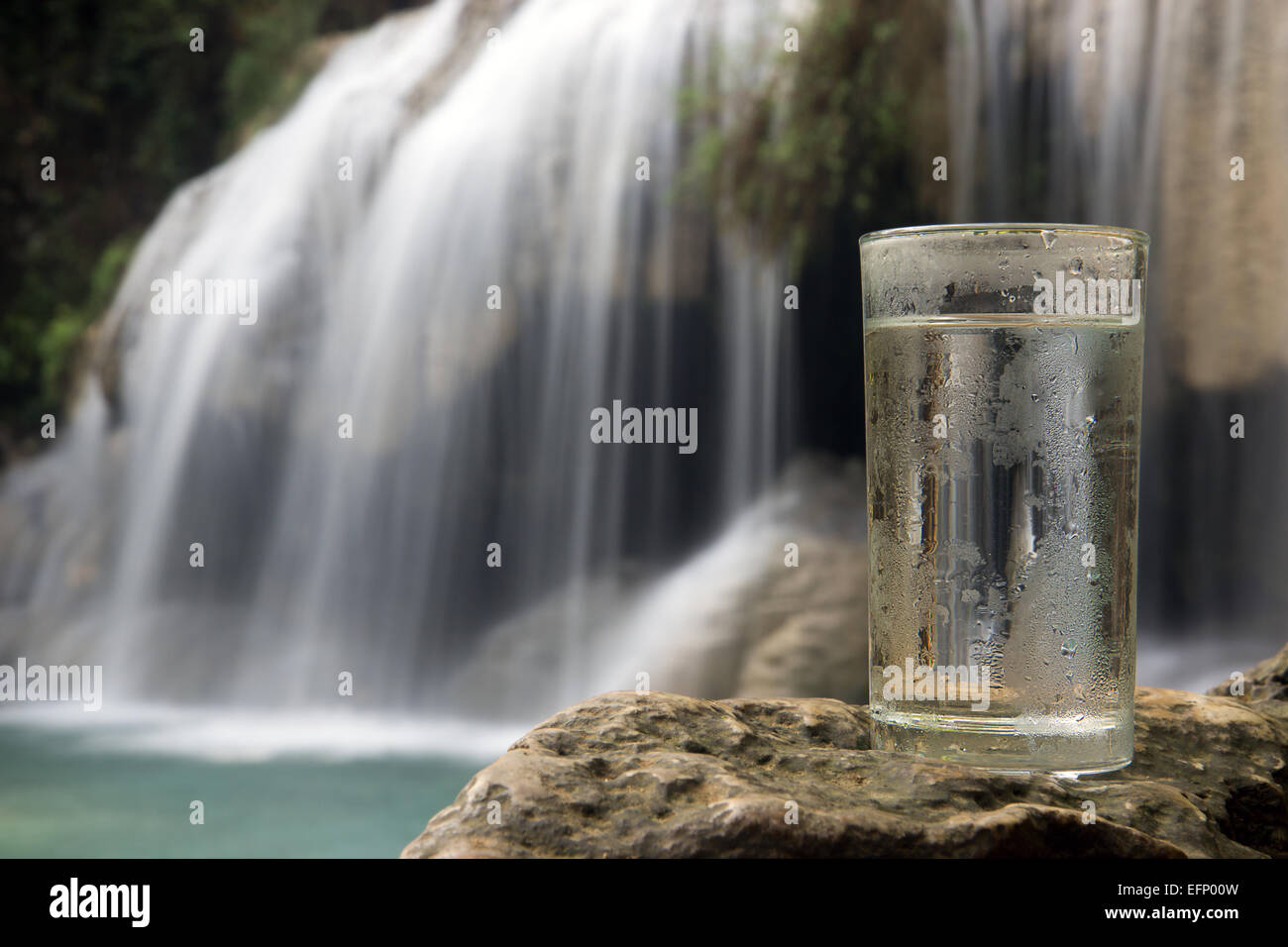 taufrische Glas Wasser auf einem Hintergrund von einem Wasserfall Stockfoto