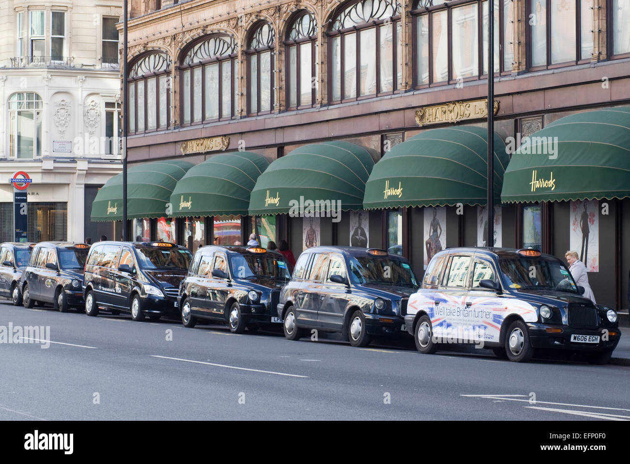 Londons berühmte schwarze Taxis geparkten außen Harrods in London Stockfoto