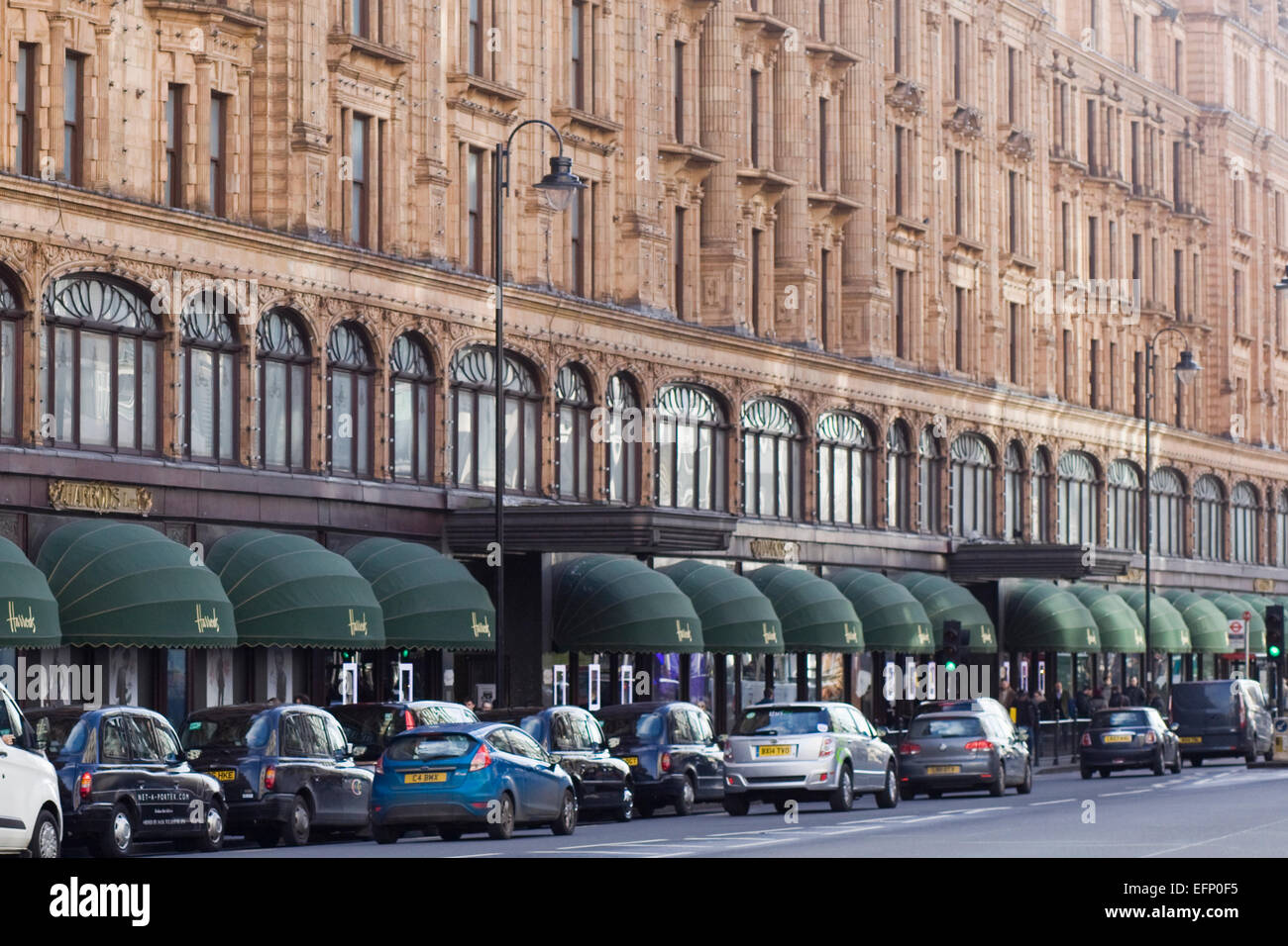 Londons berühmte schwarze Taxis geparkten außen Harrods in London Stockfoto