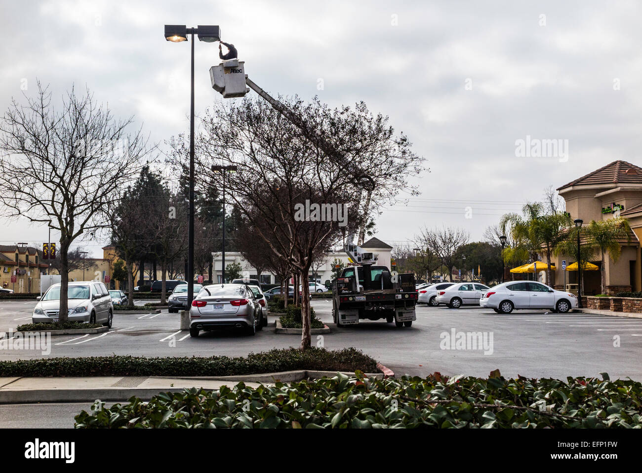 Ein Arbeiter Changing Glühbirnen in eine Parkplatz-Straßenlaterne in Modesto, Kalifornien Stockfoto