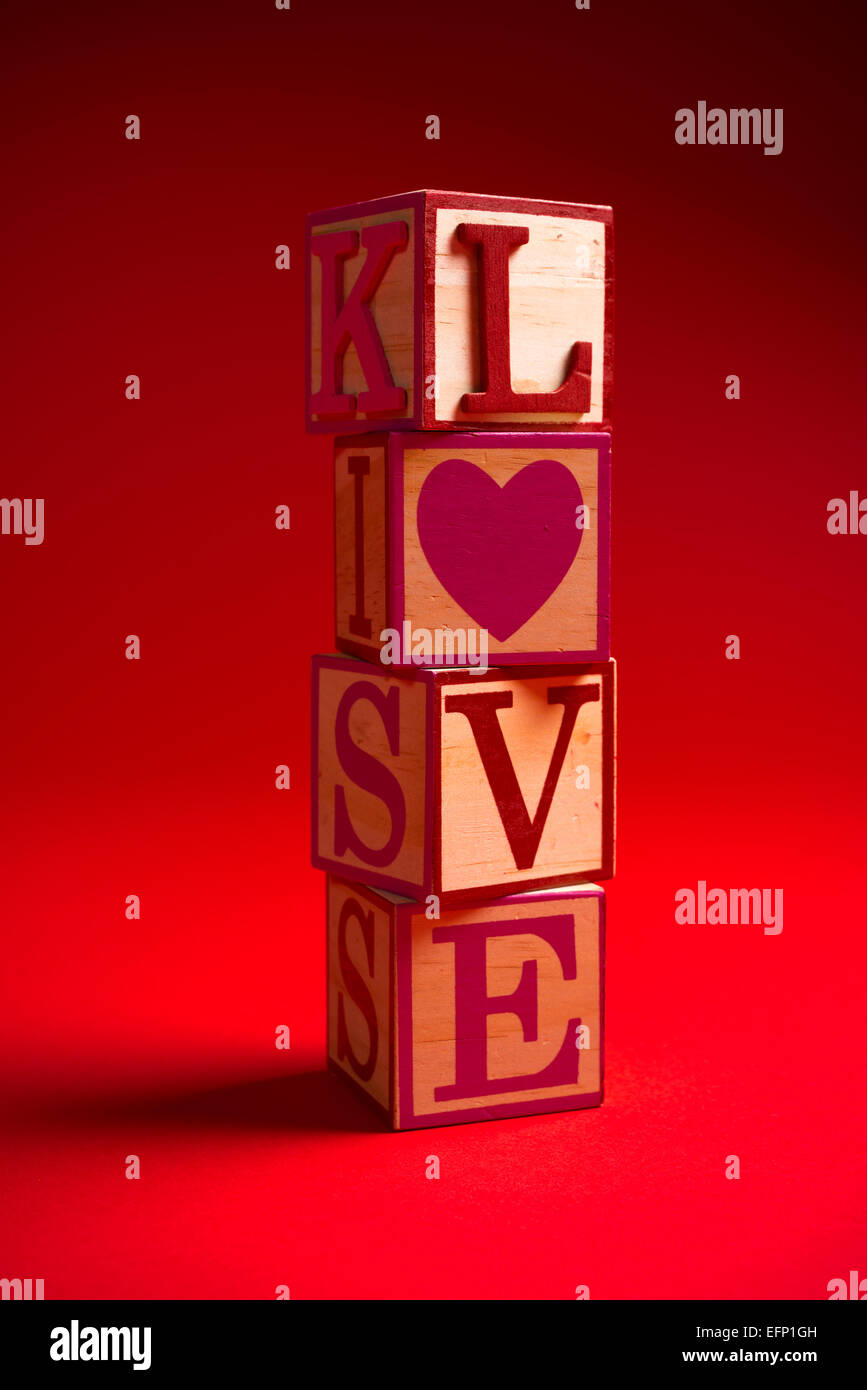 Valentinstag Dekoration mit das Wort Liebe in hölzerne Alphabet Blöcken auf einem roten Hintergrund Stockfoto