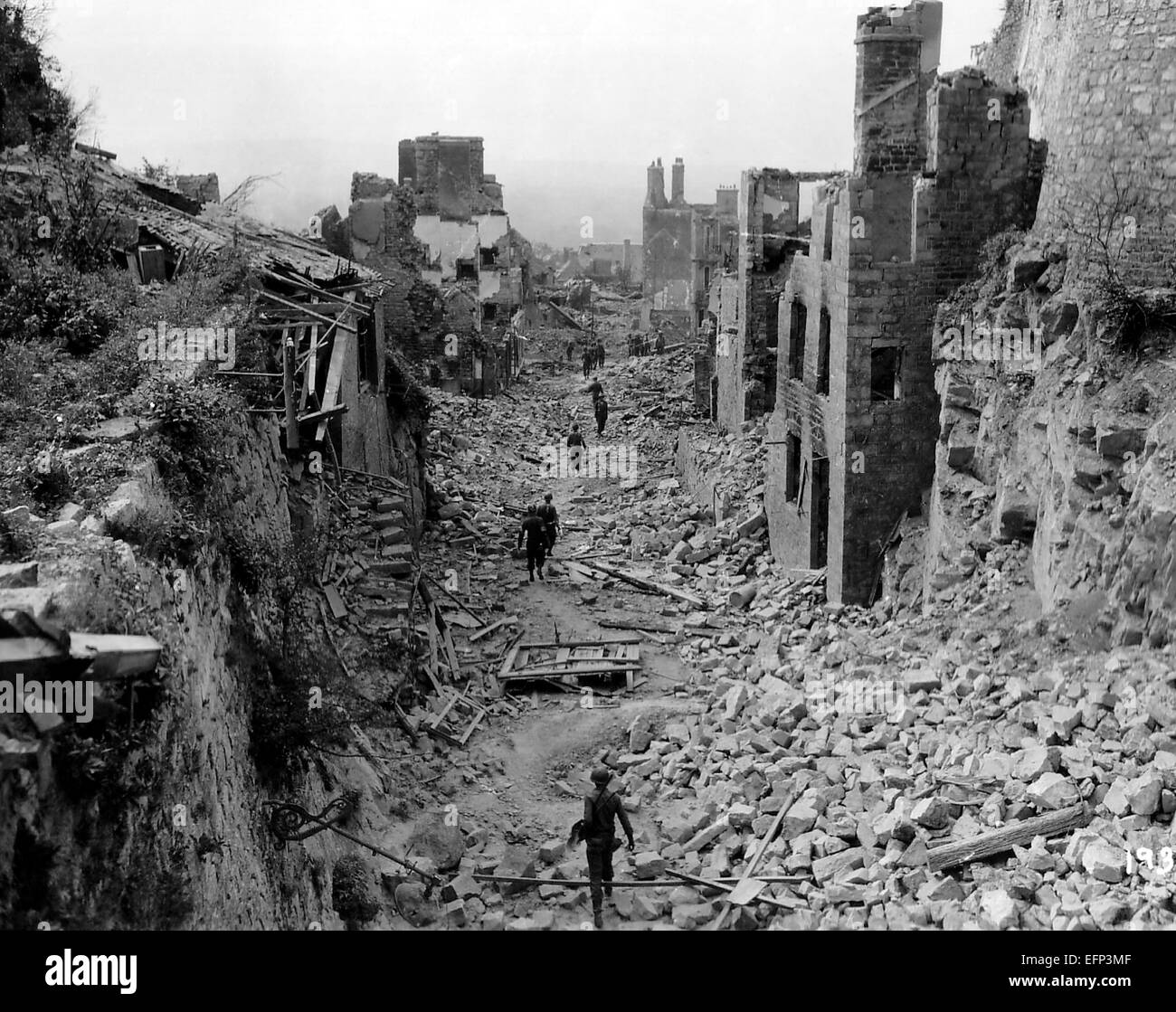 US-Armeesoldaten bewegen durch Schutt und Geröll, wie sie vorher gegen Deutschland Truppen während der Schlacht um die Normandie 6. August 1944 in Domfront, Orne, Normandie, Frankreich zu fliehen. Stockfoto