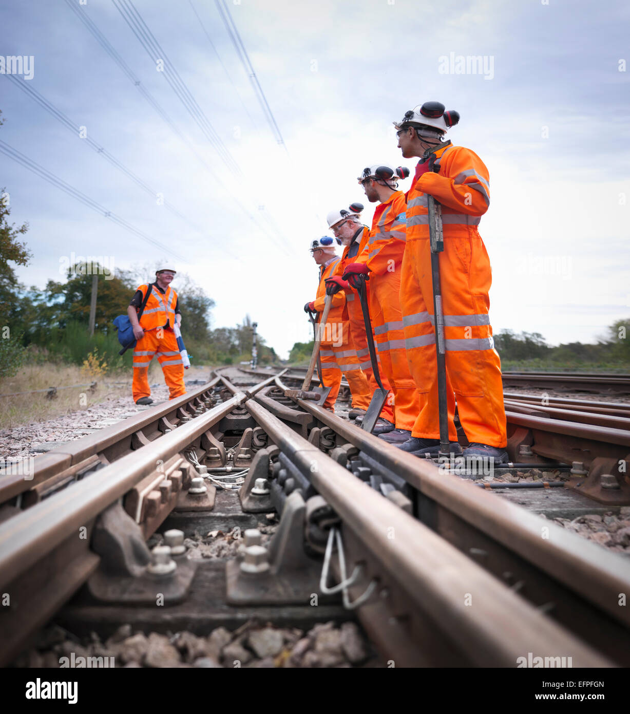 Sicherheits-Offizier mit einer Gruppe von Eisenbahnern Wartung stehen auf dem richtigen Weg Stockfoto
