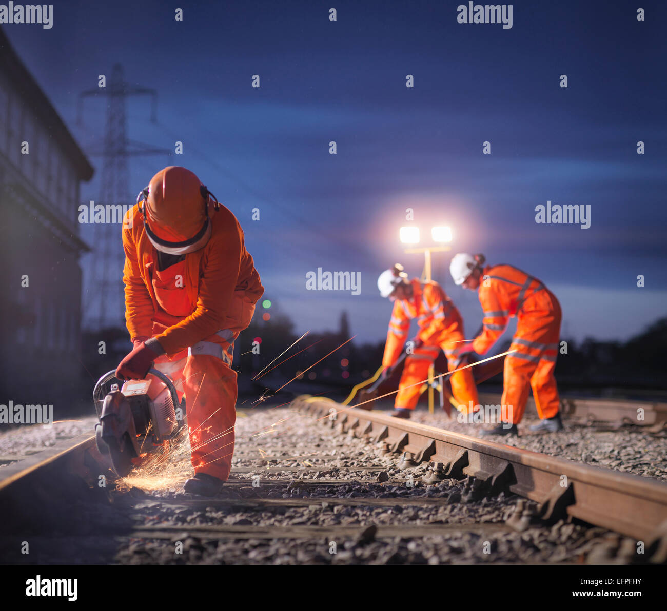 Wartung der Eisenbahner mit Schleifer auf dem richtigen Weg in der Nacht Stockfoto