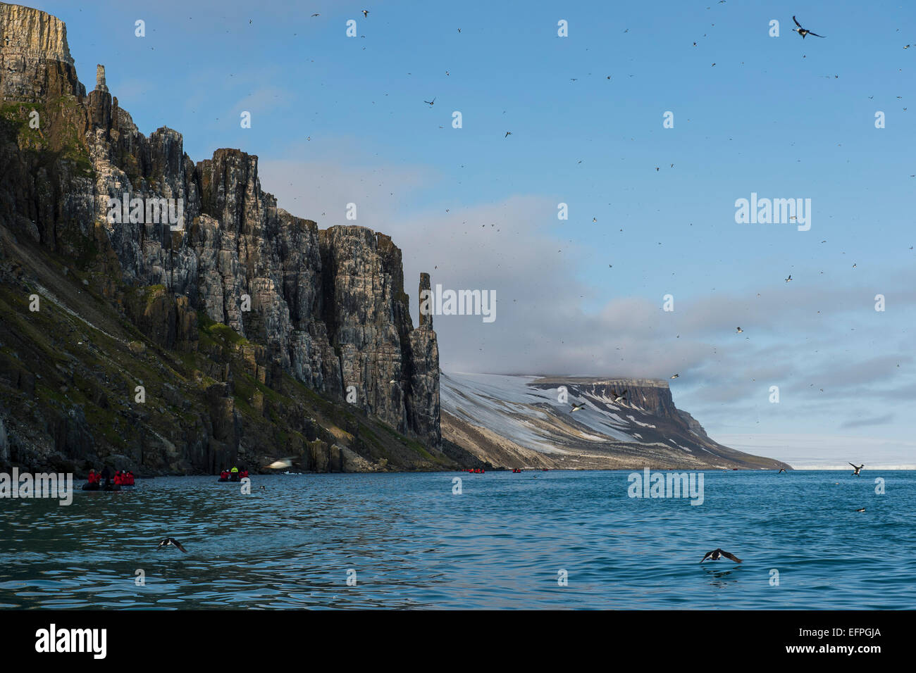 Tourist in Zodiacs Blick auf Klippen von Alkerfjellet mit Tausenden von Kittywakes, Spitzbergen, Arktis Stockfoto